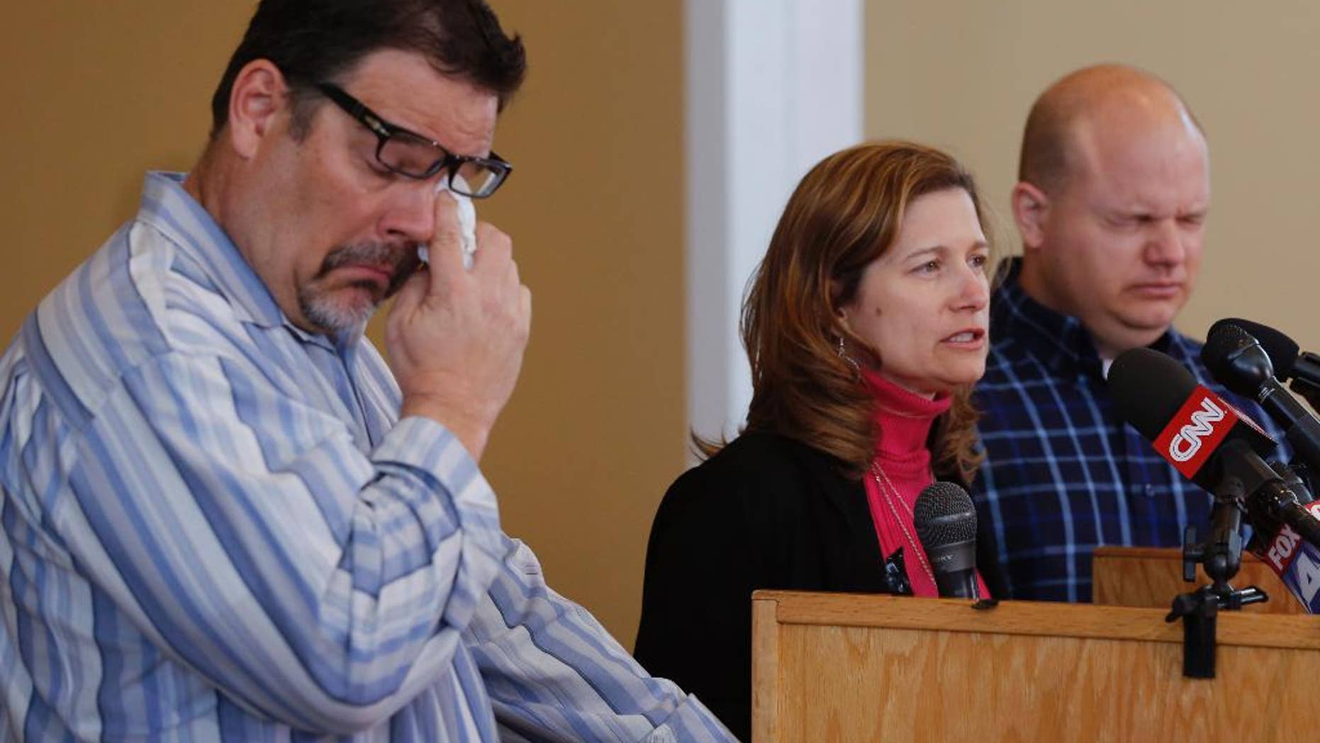 Will Corporon, left, and Tony Corporon, right, fight emotions while Mindy Losen, center, talks about her son and father during a news conference at their church in Leawood, Kan., Monday, April 14, 2014. Dr. William Corporon and his 14-year-old grandson were victims of Sunday's shooting at the Jewish Community Center. The three are sons and daughter of Dr. Corporon and Losen is the mother of the 14-year-old victim. (AP Photo/Orlin Wagner)
