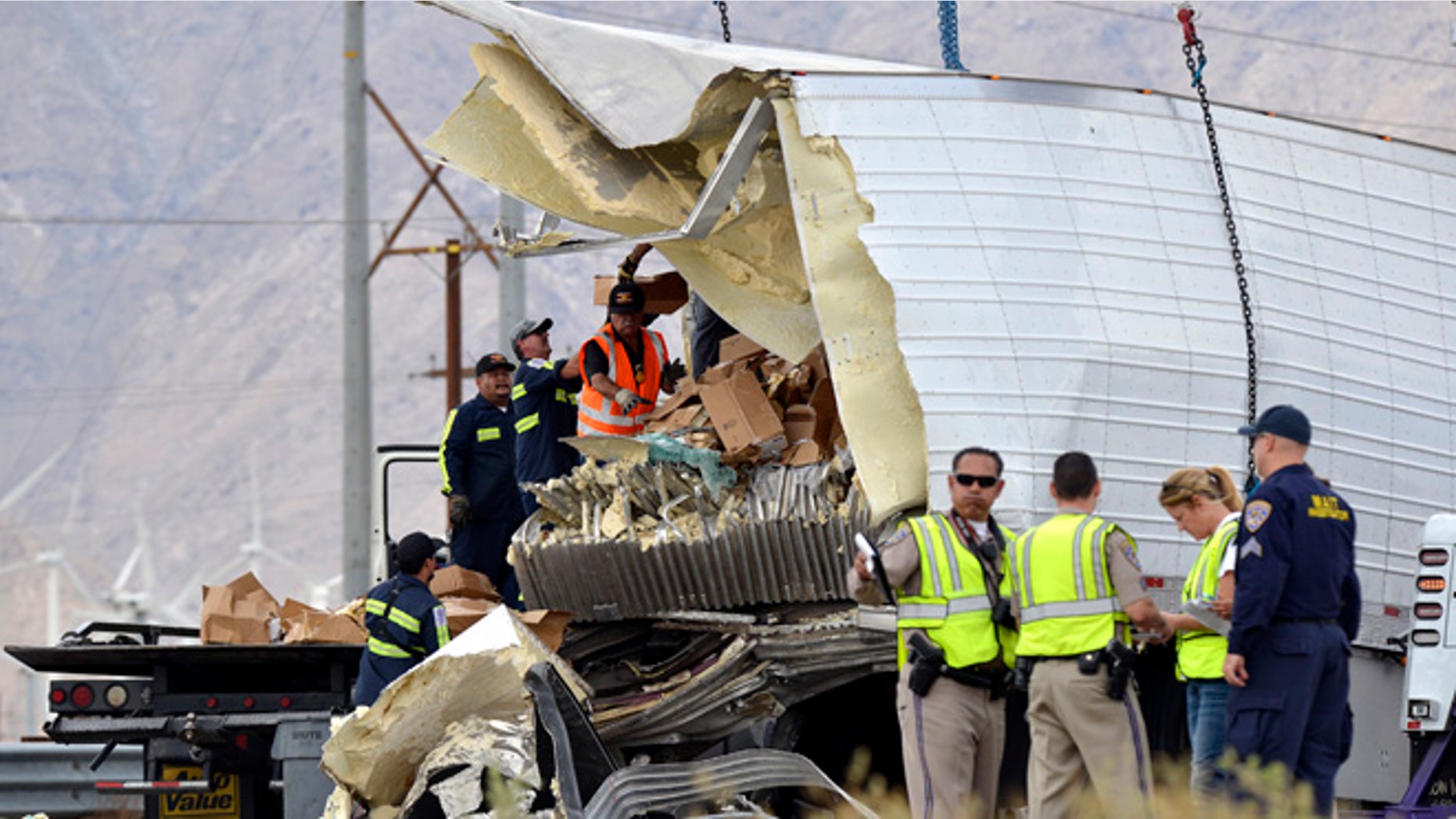 Workers remove debris from a semi-truck that crashed with a tour bus near Palm Springs, Calif., Sunday, Oct. 23, 2016.