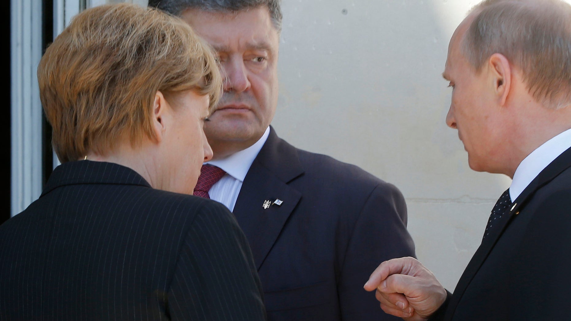 June 6, 2014 - German Chancellor Angela Merkel, left, Russian President Vladimir Putin, right, and Ukrainian president-elect Petro Poroshenko, center, talk after a group photo before a luncheon as they take part in the 70th anniversary of D-Day in Benouville in Normandy, France.