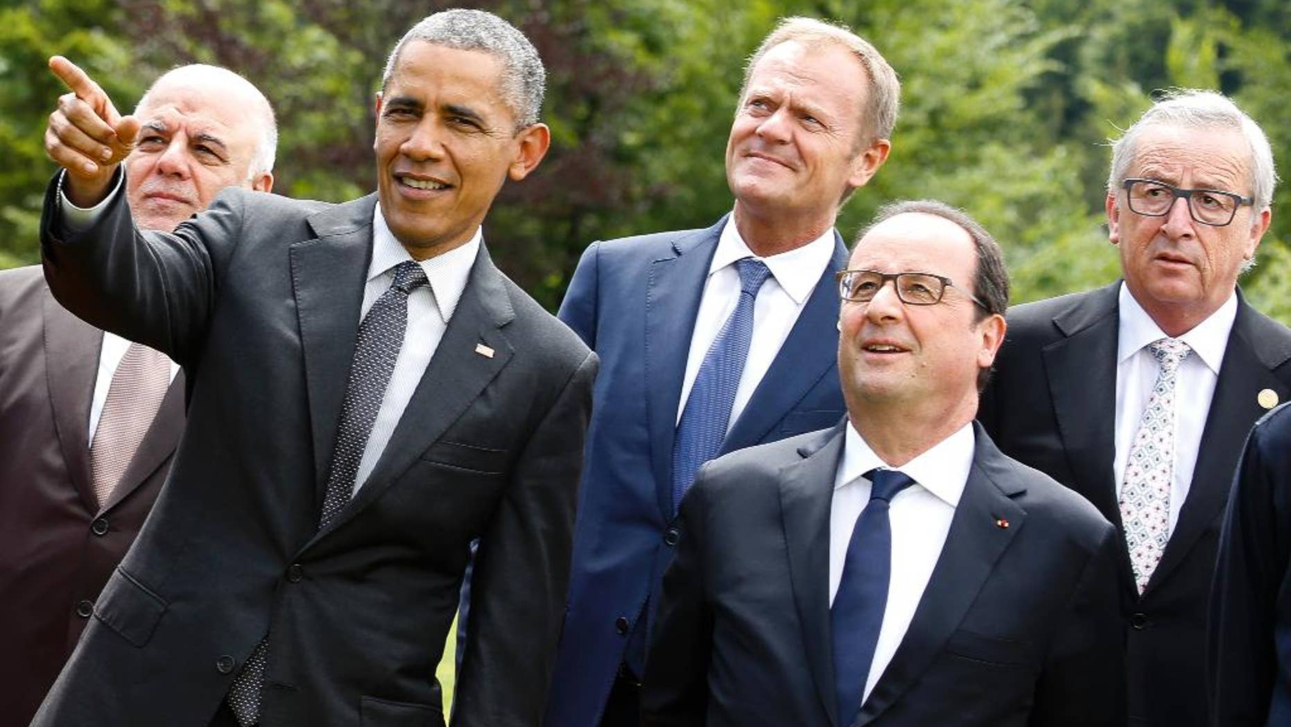 U.S. President Barack Obama, second left, points during a group photo of G-7 leaders and Outreach guests at the G-7 summit at Schloss Elmau hotel near Garmisch-Partenkirchen, southern Germany, Monday, June 8, 2015. Other leaders from left, Iraq's Prime Minister Haider al-Abadi, European Council President Donald Tusk, French President Francois Hollande and European Commission President Jean-Claude Juncker. (AP Photo/Markus Schreiber)
