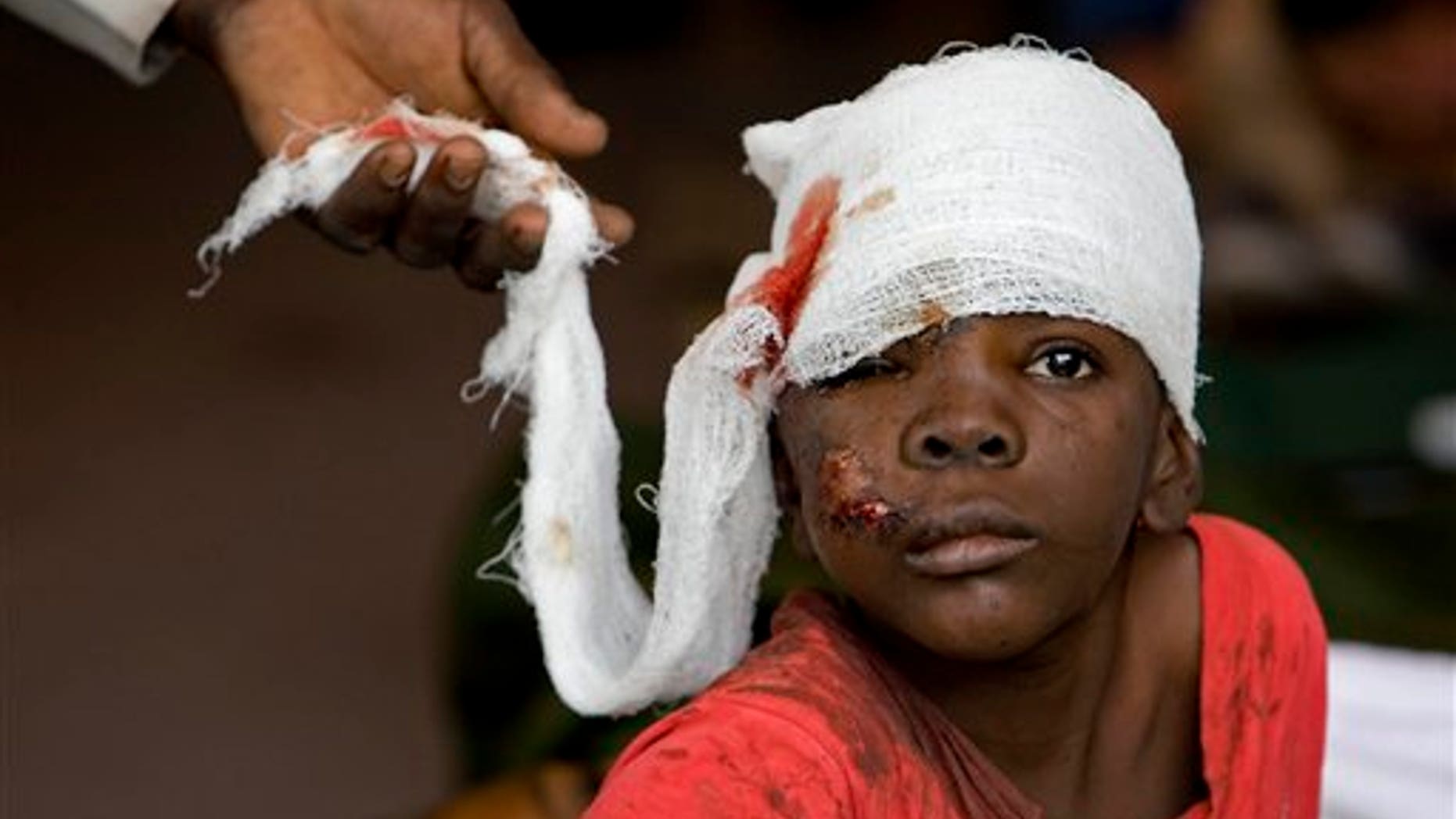 In this photo released by the United Nations, an injured earthquake survivor receives treatment at a medical clinic set up at MINUSTAH's logistics base in Port-au-Prince, Haiti, Wednesday, Jan. 13, 2010. A 7.0-magnitude earthquake struck Haiti Tuesday. (AP Photo/United Nations, Logan Abassi)