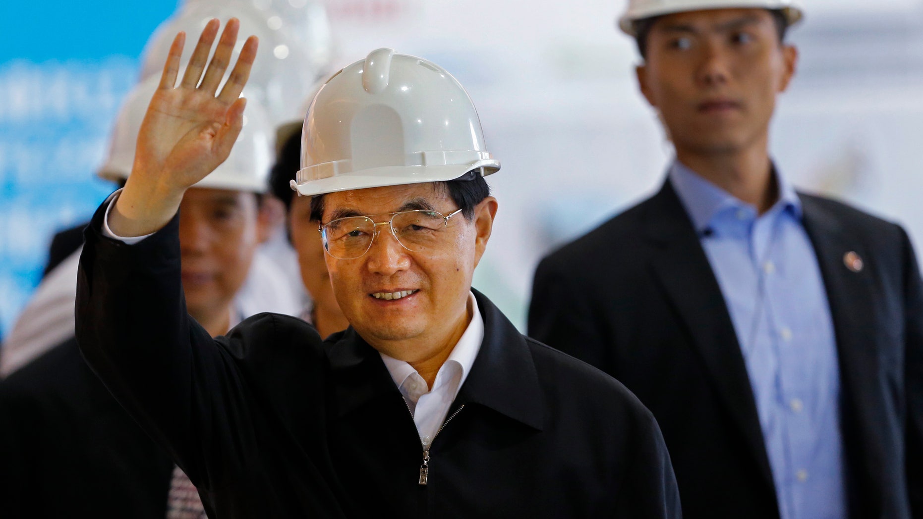 June 30, 2012: Chinese President Hu Jintao waves to reporters during a visit to the Kai Tak Cruise Terminal Building in Hong Kong.