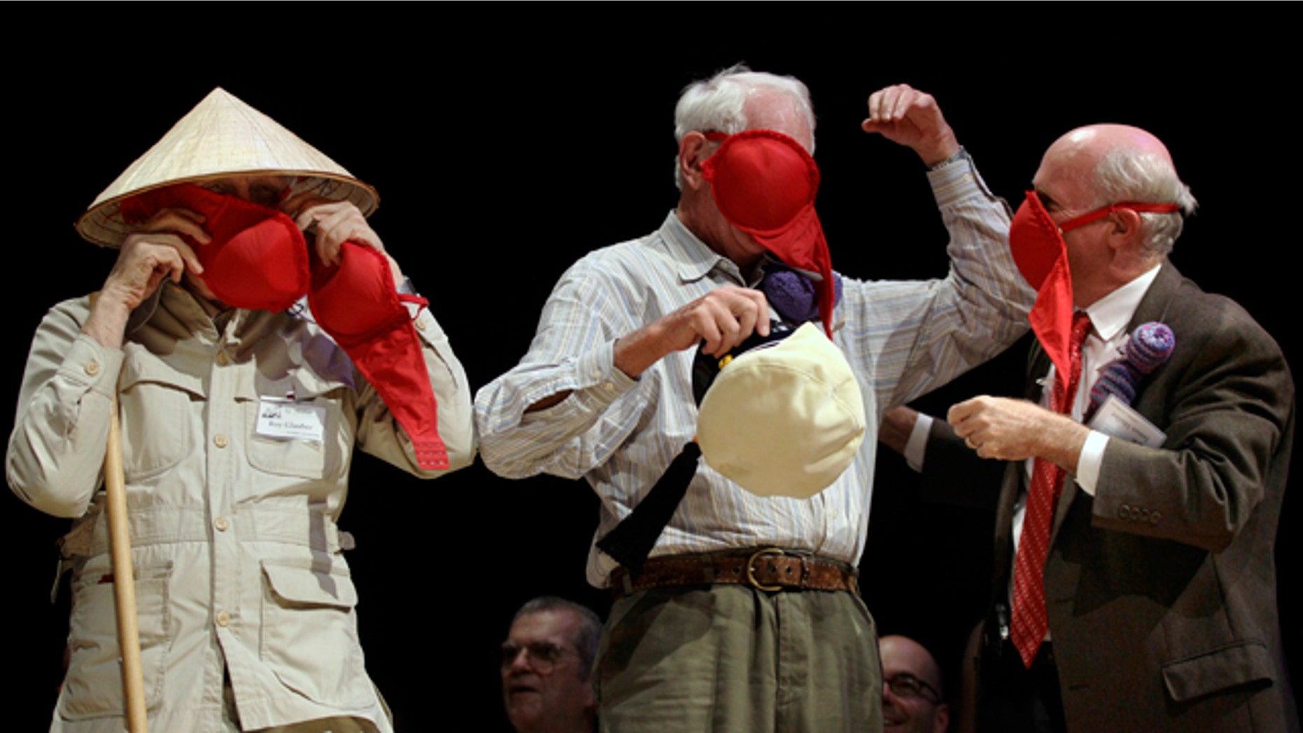 Nobel laureates Roy Glauber (Physics, 2005), left, Sheldon Glashow (Physics, 1979), center, and James Muller (Peace, 1985) demonstrate how women's bras can be used as emergency gas masks during the Ig Nobel Prize ceremony, Thursday, Sept. 30, 2010, at Harvard University in Cambridge, Mass.