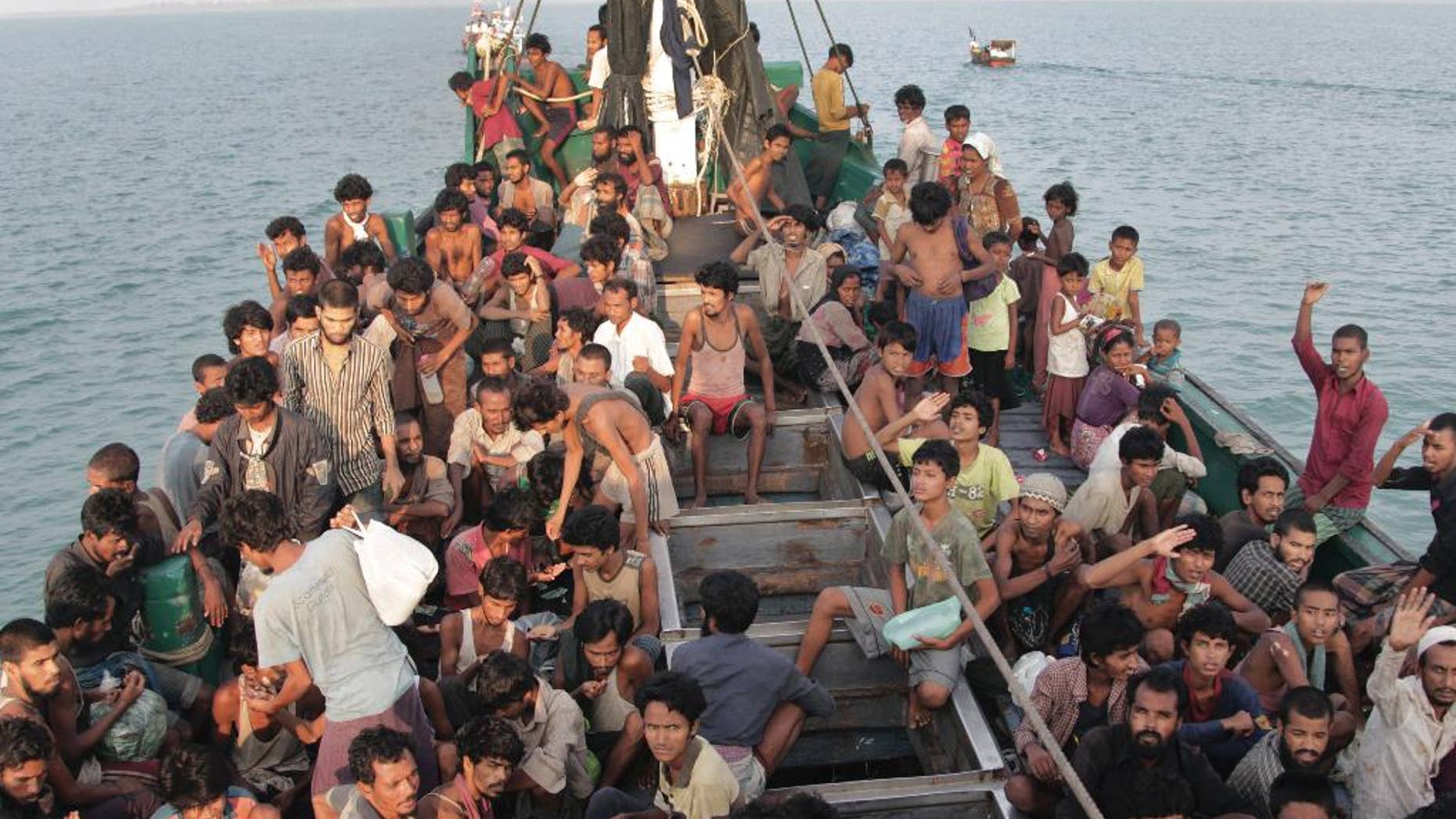 Migrants wait to be be rescued by Acehnese fishermen on their boat on the sea off East Aceh, Indonesia, Wednesday, May 20, 2015. In a potential breakthrough in Southeast Asia's humanitarian crisis, Indonesia and Malaysia offered Wednesday to provide temporary shelter to thousands of migrants stranded at sea after weeks of saying they weren't welcome. But they appealed for international help, saying the crisis was a global, not a regional, problem. (AP Photo/S. Yulinnas)