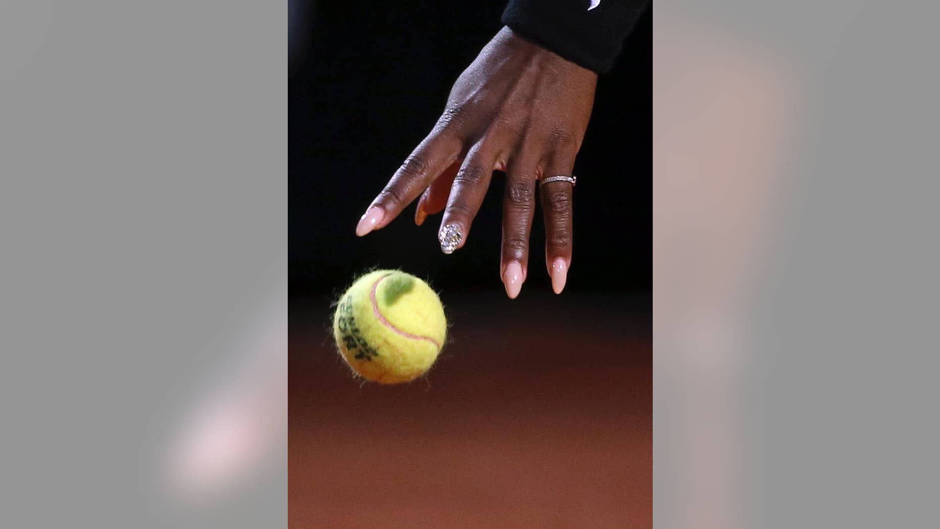 Serena Williams' hand reaches for the ball as she gets ready and serve to China's Shuai Zhang, during their match at the Italian open tennis tournament in Rome, Friday, May 16, 2014. (AP Photo/Gregorio Borgia)