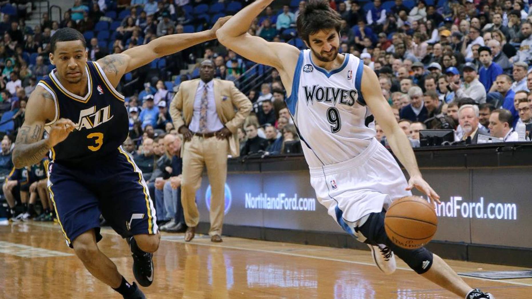 Minnesota Timberwolves guard Ricky Rubio (9), of Spain, tries to shake off Utah Jazz guard Trey Burke (3) on a drive during the fourth quarter of an NBA basketball game in Minneapolis, Wednesday, April 16, 2014. The Jazz won 136-130 in double overtime. (AP Photo/Ann Heisenfelt)