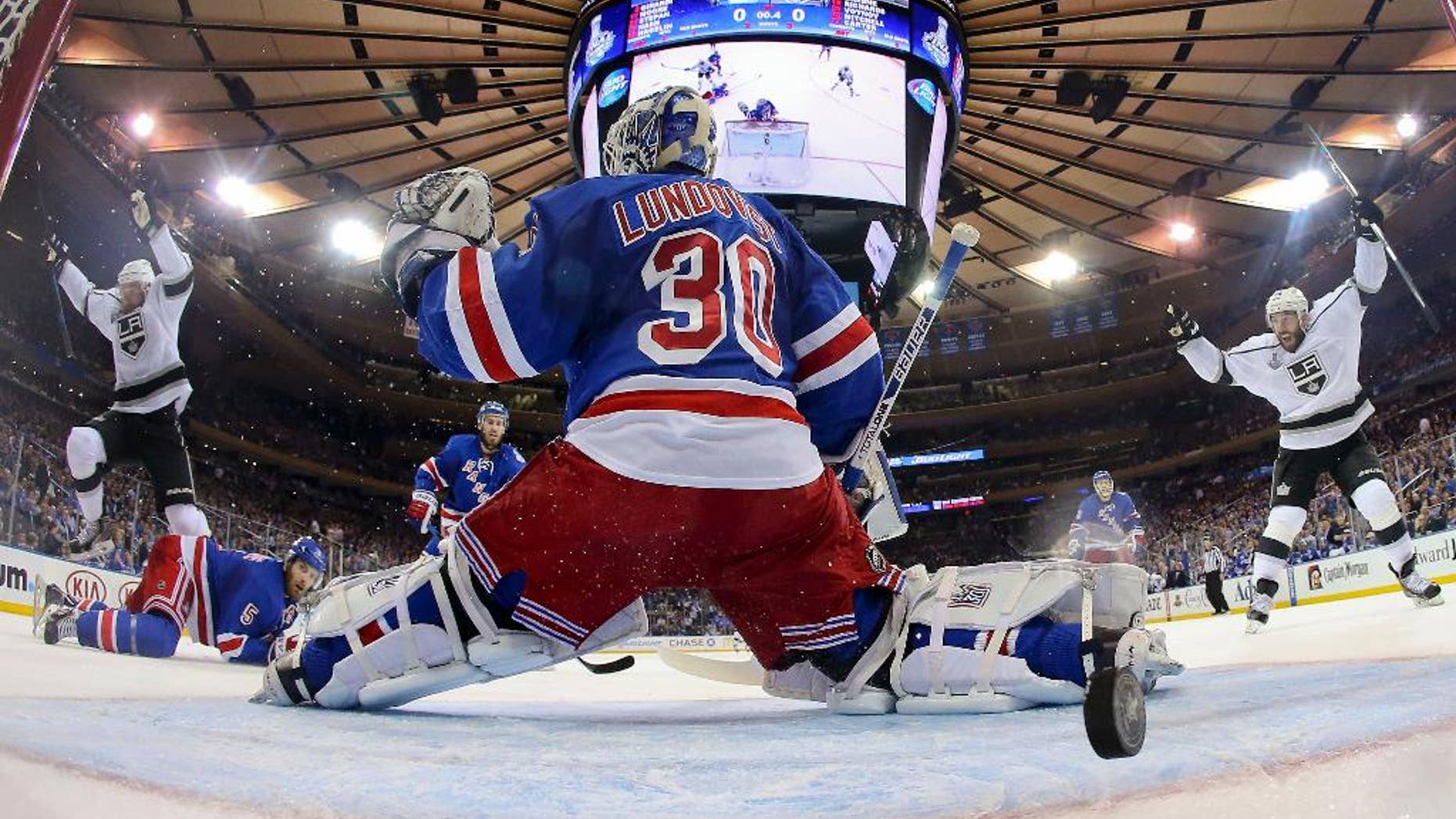 Los Angeles Kings center Jeff Carter (77), left, and left wing Dwight King (74), right, react as the puck bounces off the post and into the net past New York Rangers goalie Henrik Lundqvist (30) to end the first period during Game 3 of the NHL hockey Stanley Cup Final, Monday, June 9, 2014, in New York. (AP Photo/Bruce Bennett, Pool)