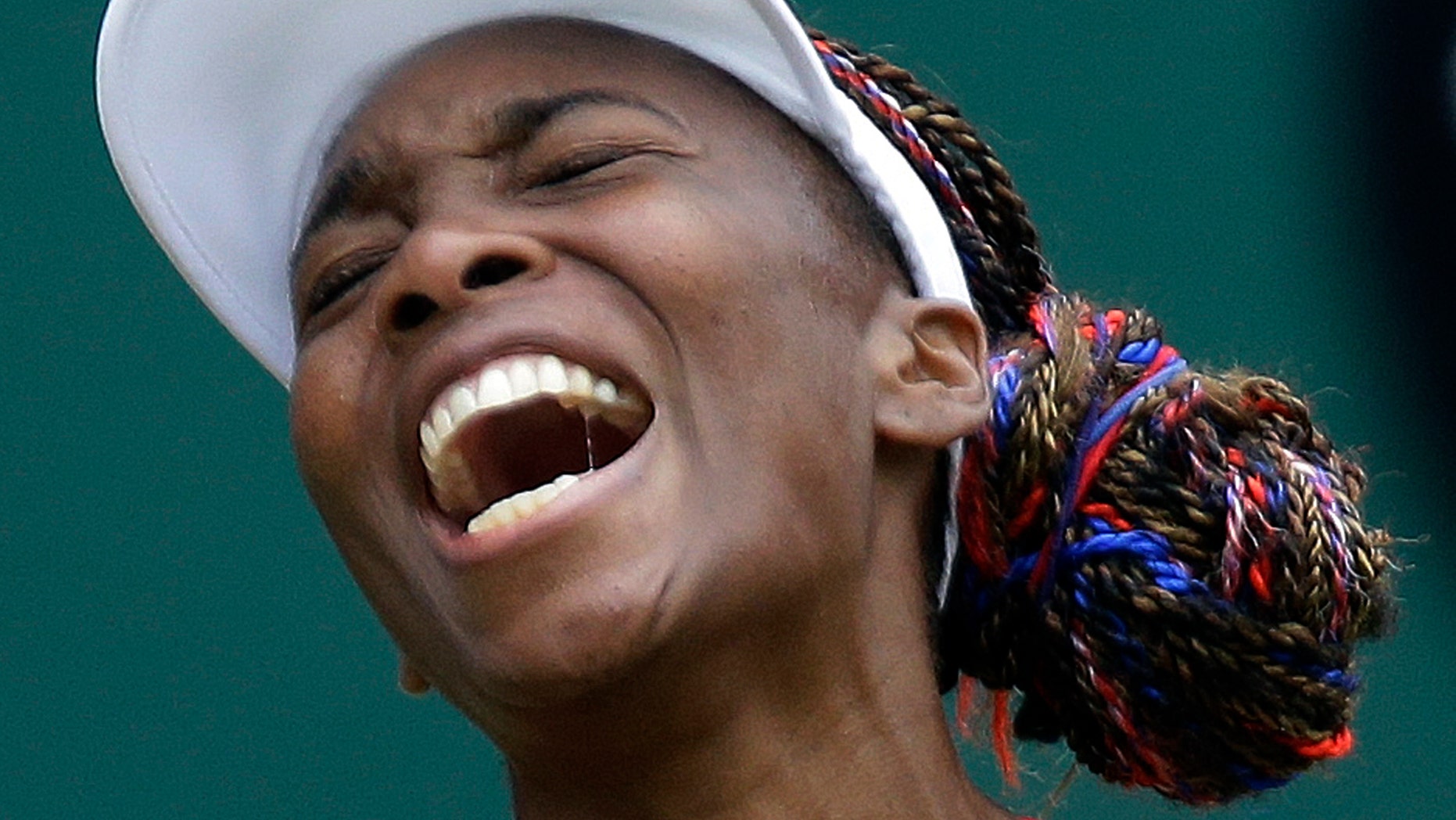 Venus Williams of the United States screams during her match against Aleksandra Wozniak of Canada at the All England Lawn Tennis Club in Wimbledon, London at the 2012 Summer Olympics, Tuesday, July 31, 2012. (AP Photo/Elise Amendola)