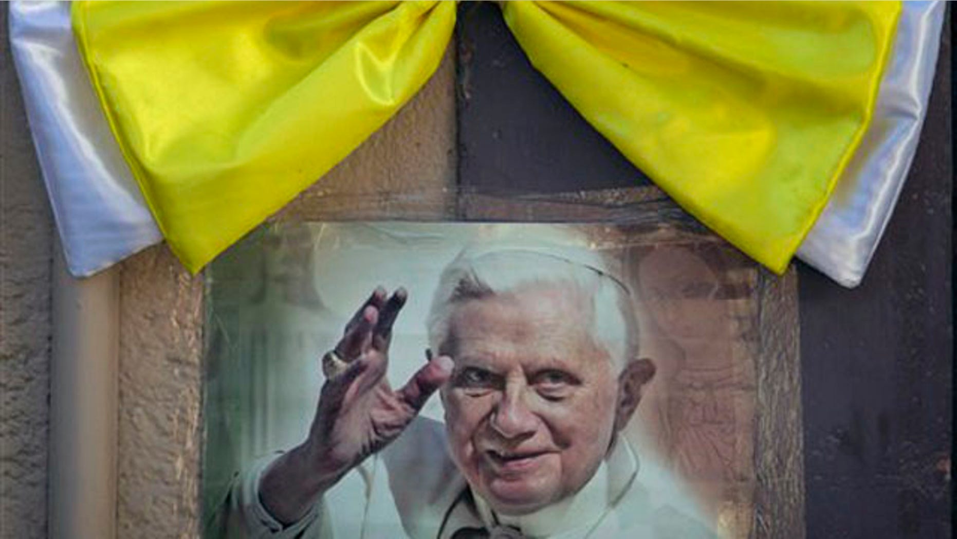 March 22, 2012: An image of Pope Benedict XVI is taped to a wall, topped with a Vatican-colored bow, in Leon, Mexico.