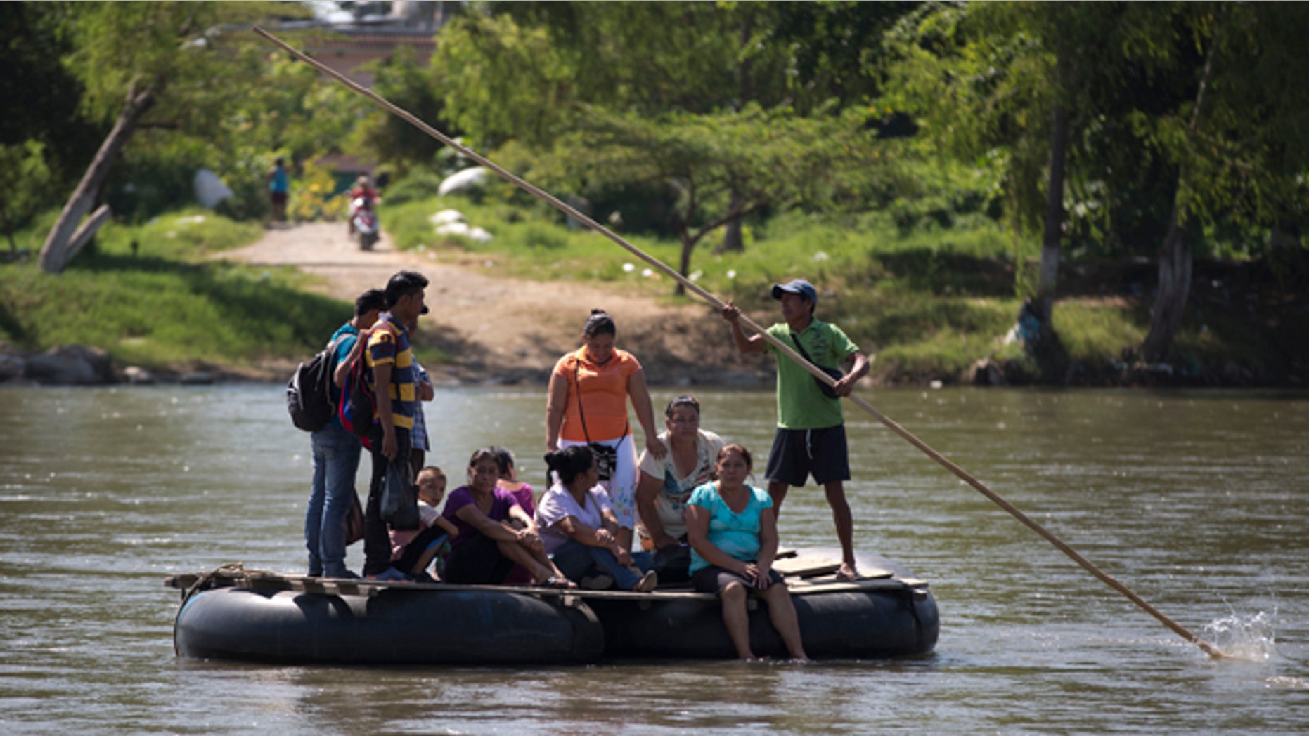 July 11, 2014: People are rafted to the Mexican shore, across the Suchiate river that separates Tecun Uman, Guatemala and Ciudad Hidalgo, Mexico, on a makeshift raft made from inner tubes of trucks attached to wooden boards. Scores of Central Americans pay a modest fee crossing the river on these improvised rafts. (AP Photo/Eduardo Verdugo)