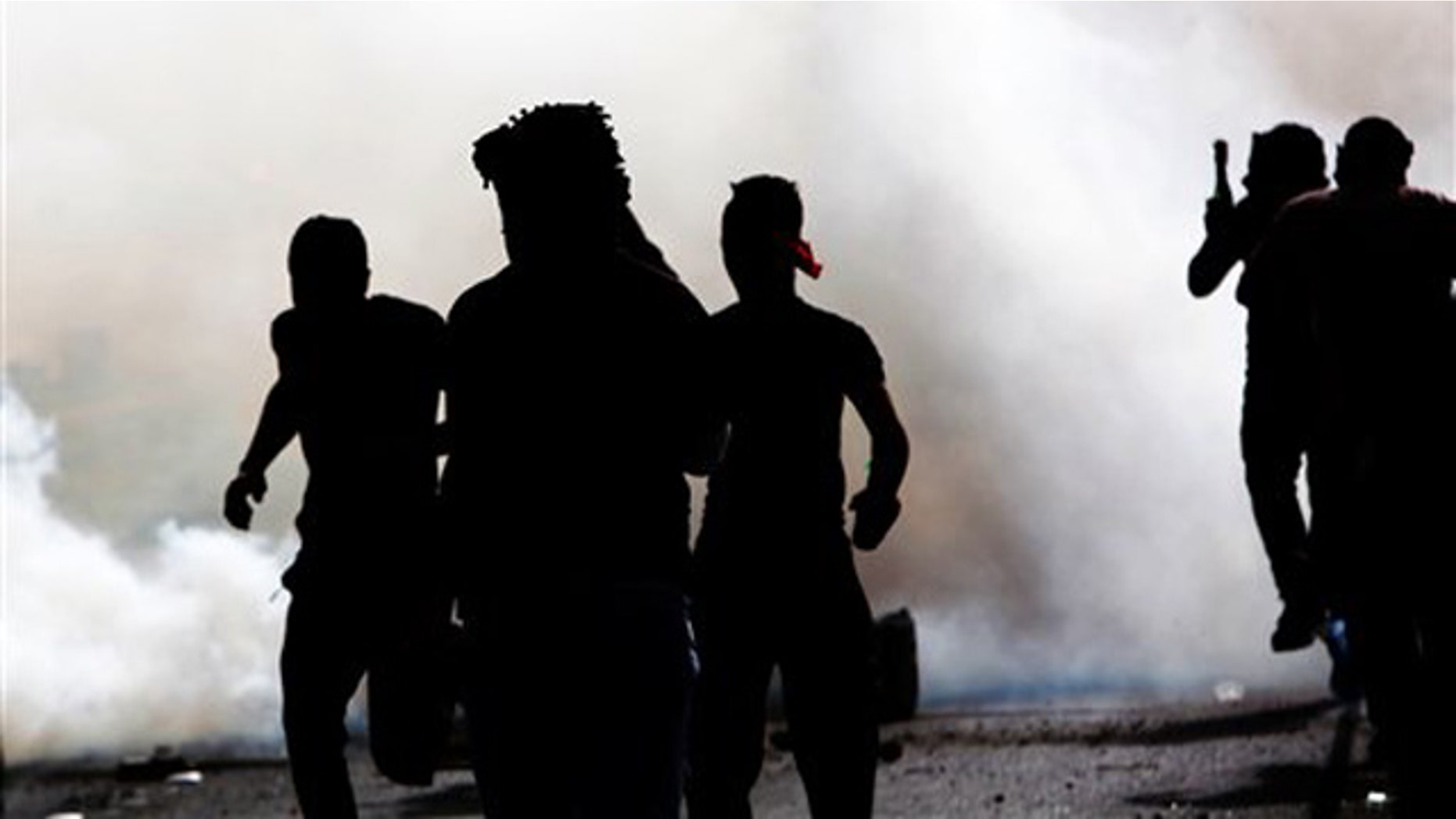March 31, 2012: Bahraini anti-government protesters react to tear gas fired by riot police Saturday.