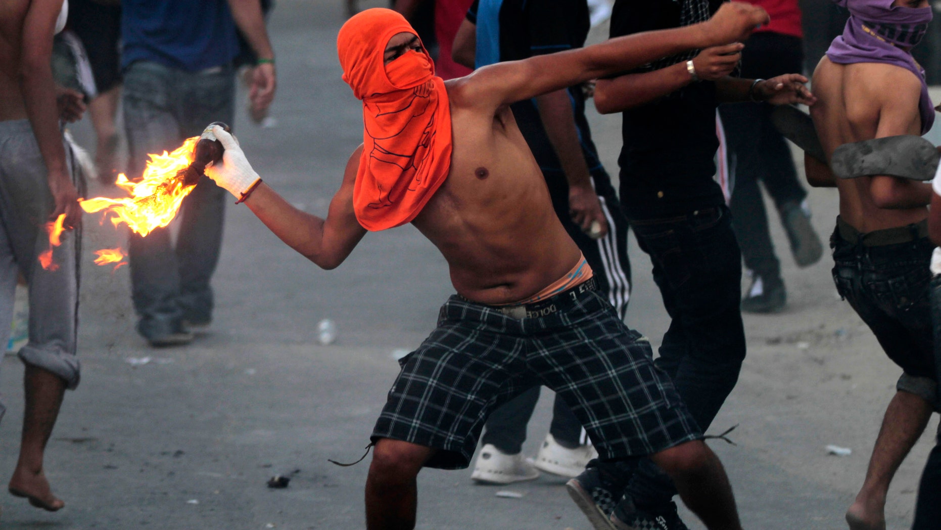 Oct. 3, 2012 - A Bahraini anti-government protester throws a petrol bomb toward riot police, unseen, firing tear gas and stun grenades in Sadad, Bahrain.
