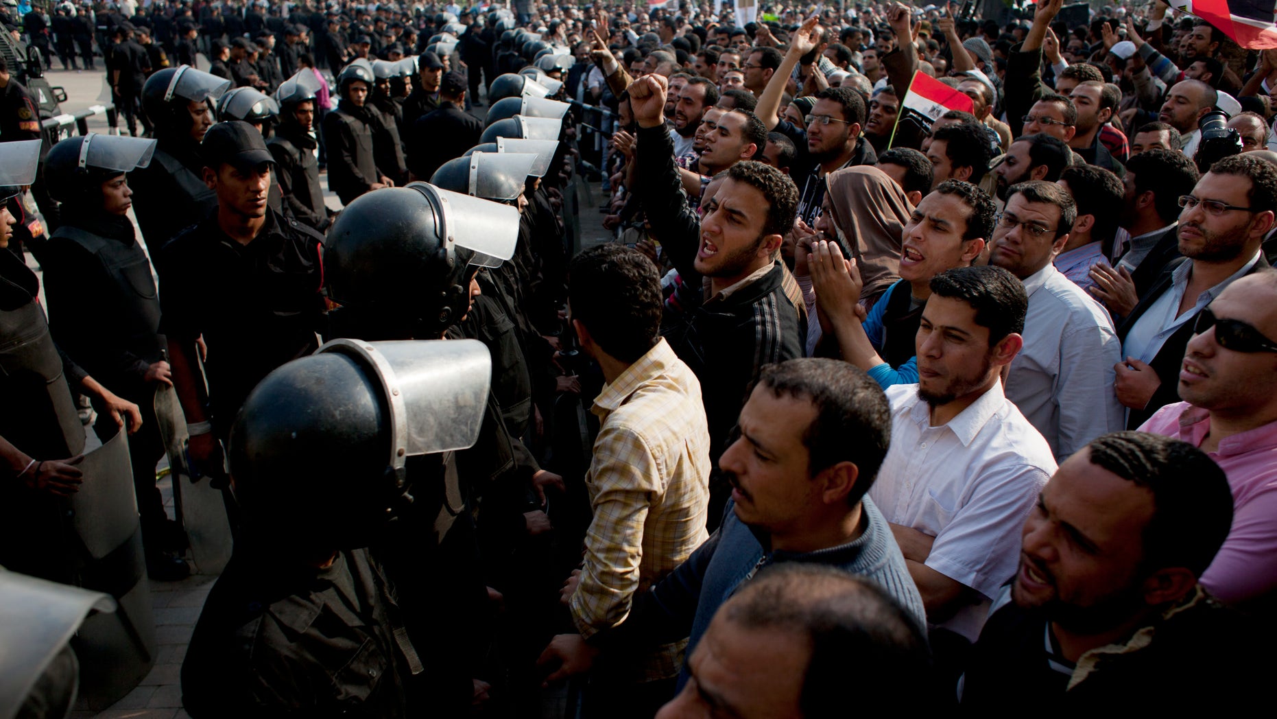 Dec. 2, 2012 - Supporters of Egyptian President Mohammed Morsi chant slogans as riot police stand guard in front of the entrance of Egypt's top court, in Cairo.