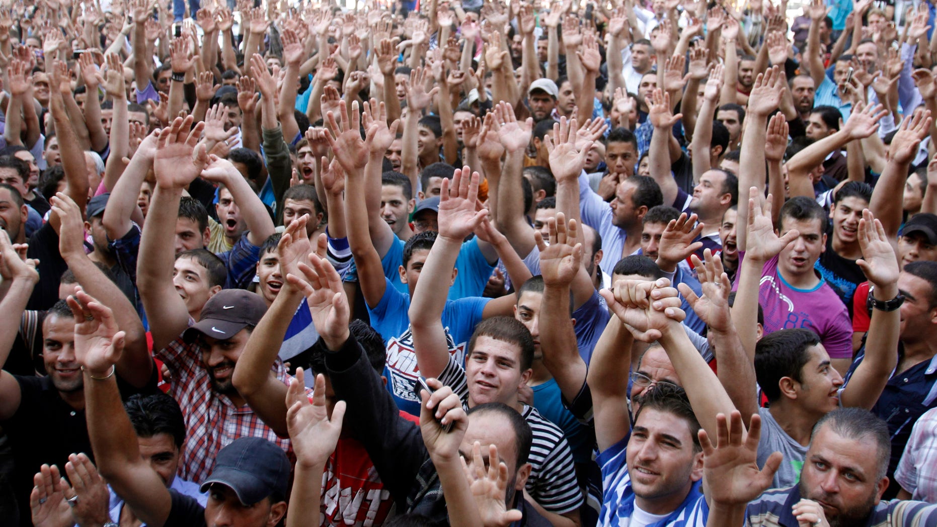 Palestinians chant slogans against Palestinian Prime Minister Salam Fayyad during a protest against the high cost of living in the West Bank city of Hebron, Monday, Sept. 10, 2012. Palestinian demonstrators fed up with high prices and unpaid salaries shuttered shops, halted traffic with burning tires and closed schools throughout the West Bank on Monday in the largest show of popular discontent with the governing Palestinian Authority in its 18-year history. (AP Photo/Nasser Shiyoukhi)