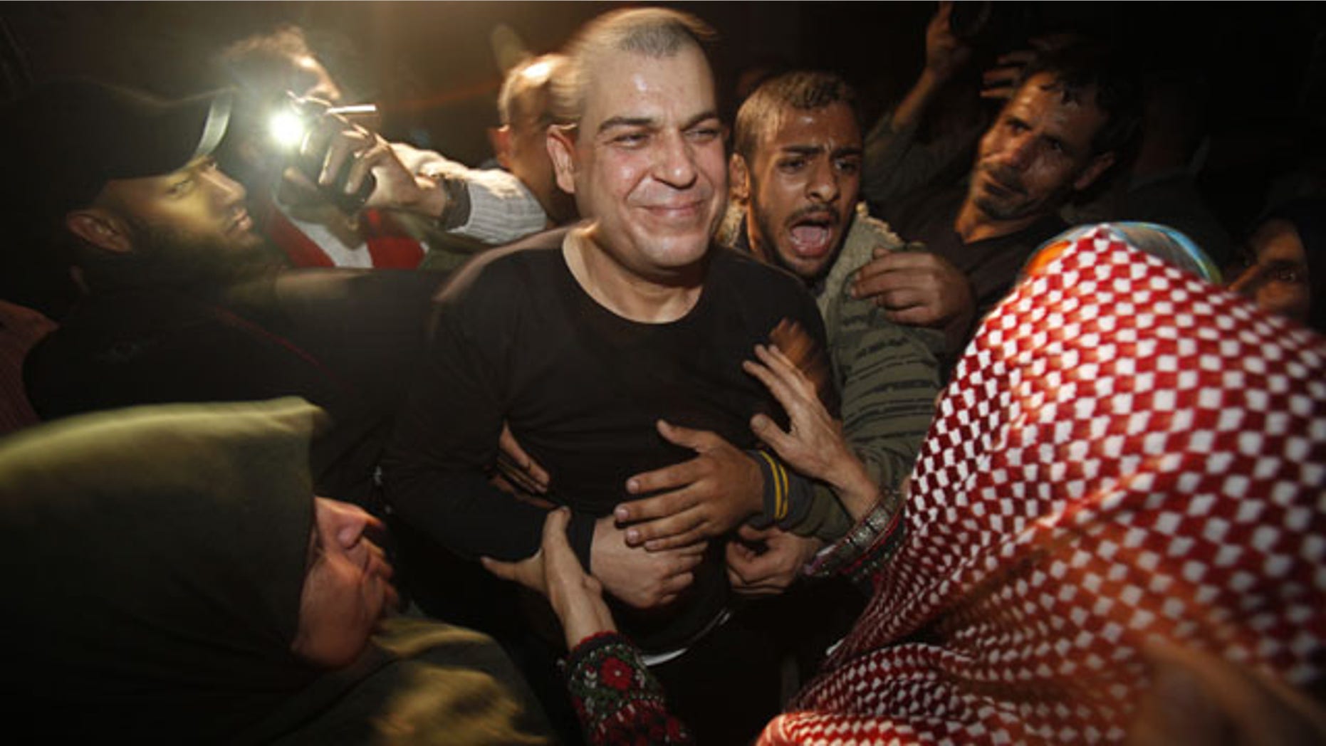 October 30, 2013: A released Palestinian prisoner, Omar Masoud, 40, center, who was arrested in May, 1993 for killing an Israeli lawyer, smiles to his mother Tamam Masoud, 70, right, upon his arrival to his family house in Shati Refugee Camp. (AP Photo)