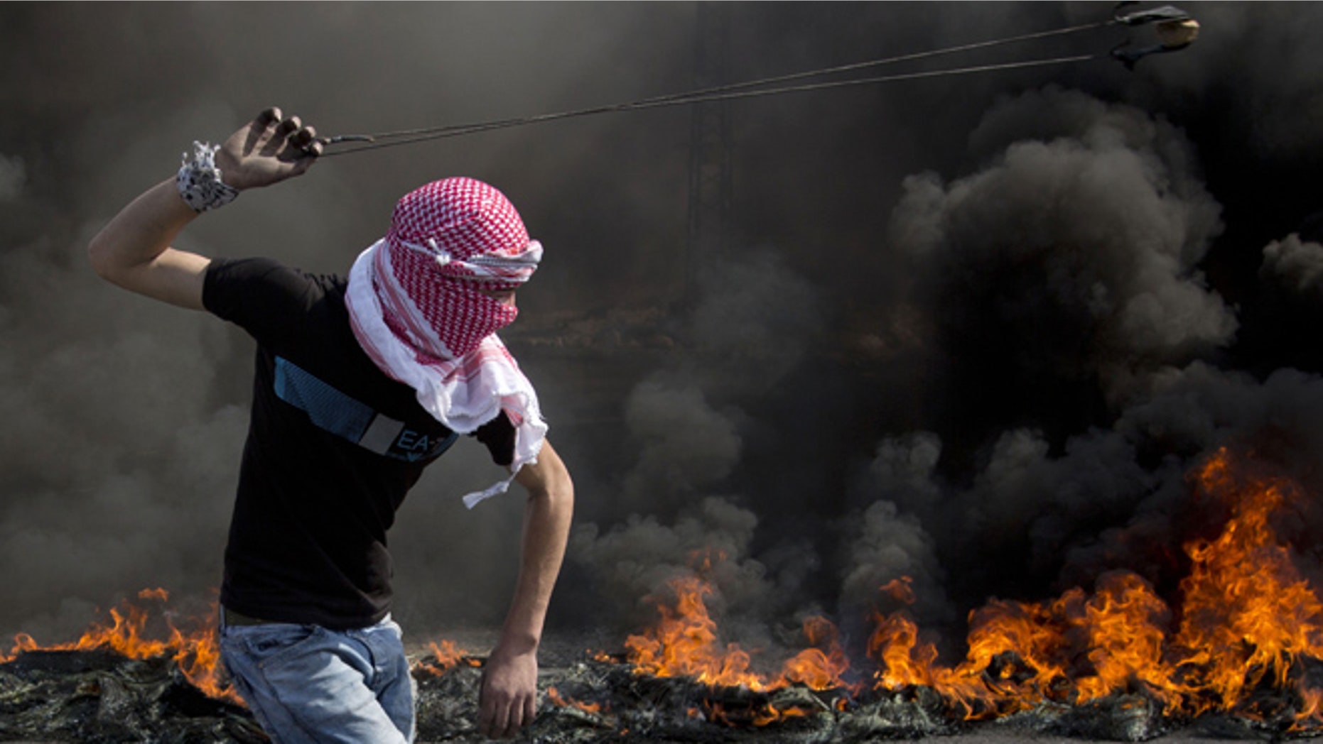 Oct. 20, 2015: A Palestinian swings a sling during clashes with Israeli troops, near Ramallah, West Bank.