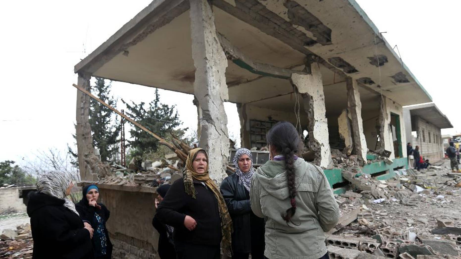 Lebanese women gather in front of damaged shops at the site of a deadly car bombing Sunday night, in the town of Nabi Othman, about 30 kilometers (18 miles) north of Baalbek, northeast Lebanon, Monday March 17, 2014. Lebanese security officials said the explosion killed at least two people and caused panic and massive destruction in the Hezbollah stronghold, which has a sizable Christian population in addition to Shiites. The civil war in neighboring Syria already has ignited polarizing sectarian tensions between Lebanon's Sunnis and Shiites. (AP Photo/Hussein Malla)