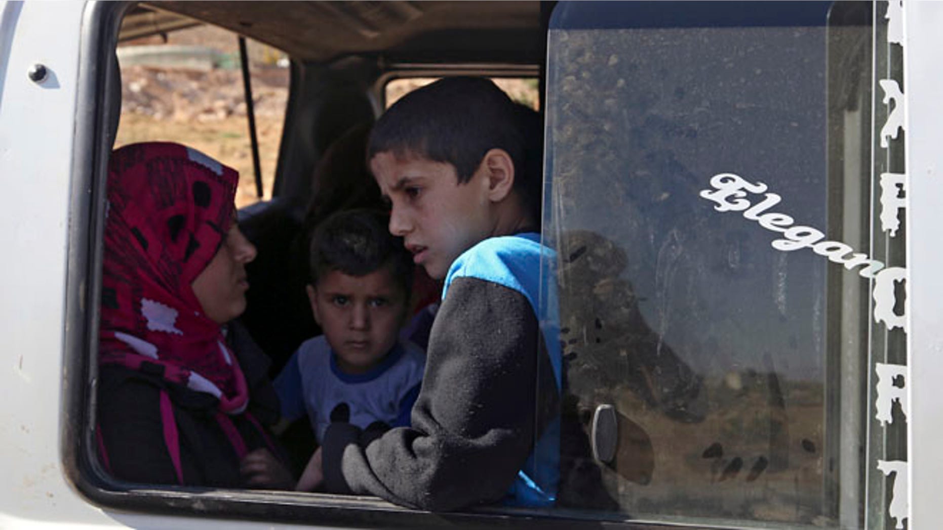 Aug. 4, 2014: A Lebanese family wait to depart in a minibus on the outskirts of Arsal, a predominantly Sunni Muslim town near the Syrian border in eastern Lebanon. (AP)