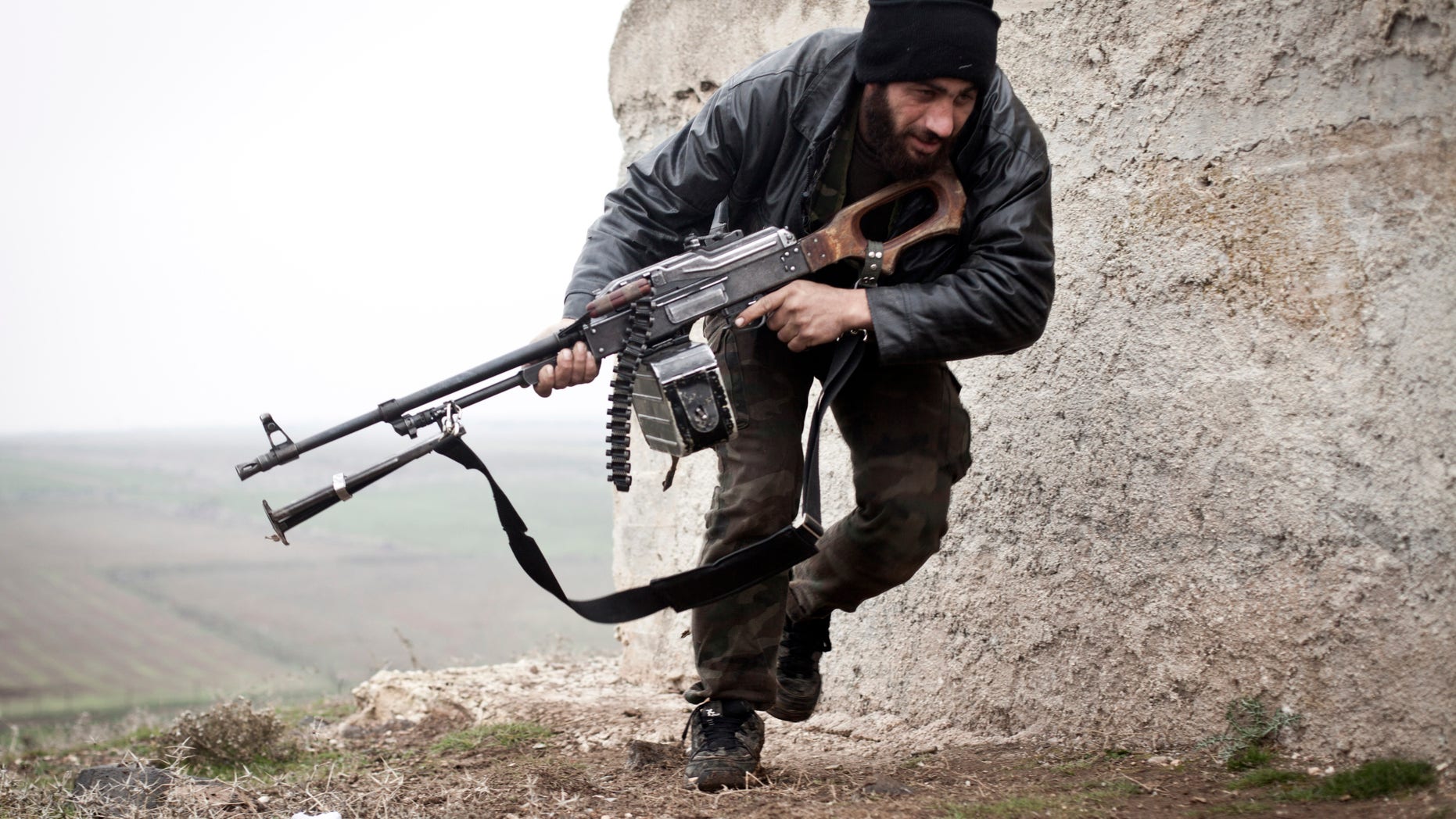 Dec. 17, 2012: In this photo, a Free Syrian Army fighter takes cover during fighting with the Syrian Army in Azaz, Syria.