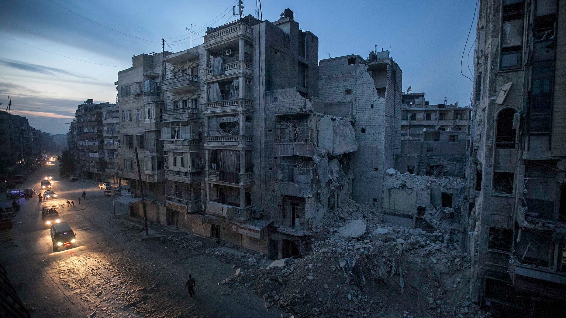 Nov. 29, 2012: In this photo, night falls on a Syrian rebel-controlled area as destroyed buildings, including Dar Al-Shifa hospital, are seen on Sa'ar street after airstrikes targeted the area last week, killing dozens in Aleppo, Syria.