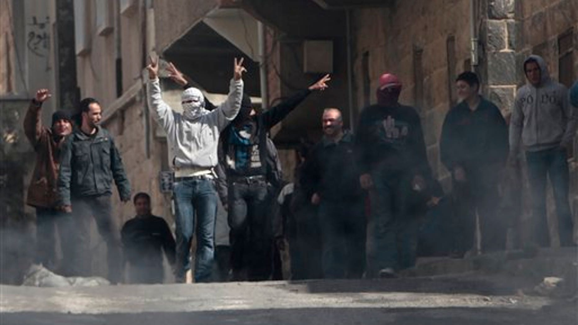 March 23: Anti-Syrian government protesters flash V sign as they protest in the southern city of Daraa, Syria. Syrian security forces shot live ammunition and tear gas near a mosque where protesters have been camped out in southern Syria, killing six people including a paramedic, activists said. The early morning attack near the al-Omari mosque in the southern city of Daraa marks the deadliest single day since anti-government protests inspired by uprisings across the Arab world reached this country last week. (AP)