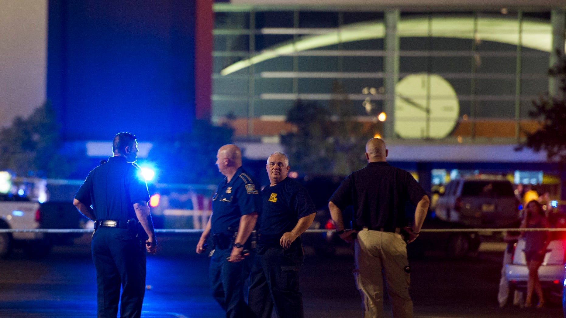 Law enforcement personnel stand near a police line at The Grand Theatre following a deadly shooting in Lafayette, La., Thursday, July 23, 2015. (Paul Kieu/The Daily Advertiser via AP)
