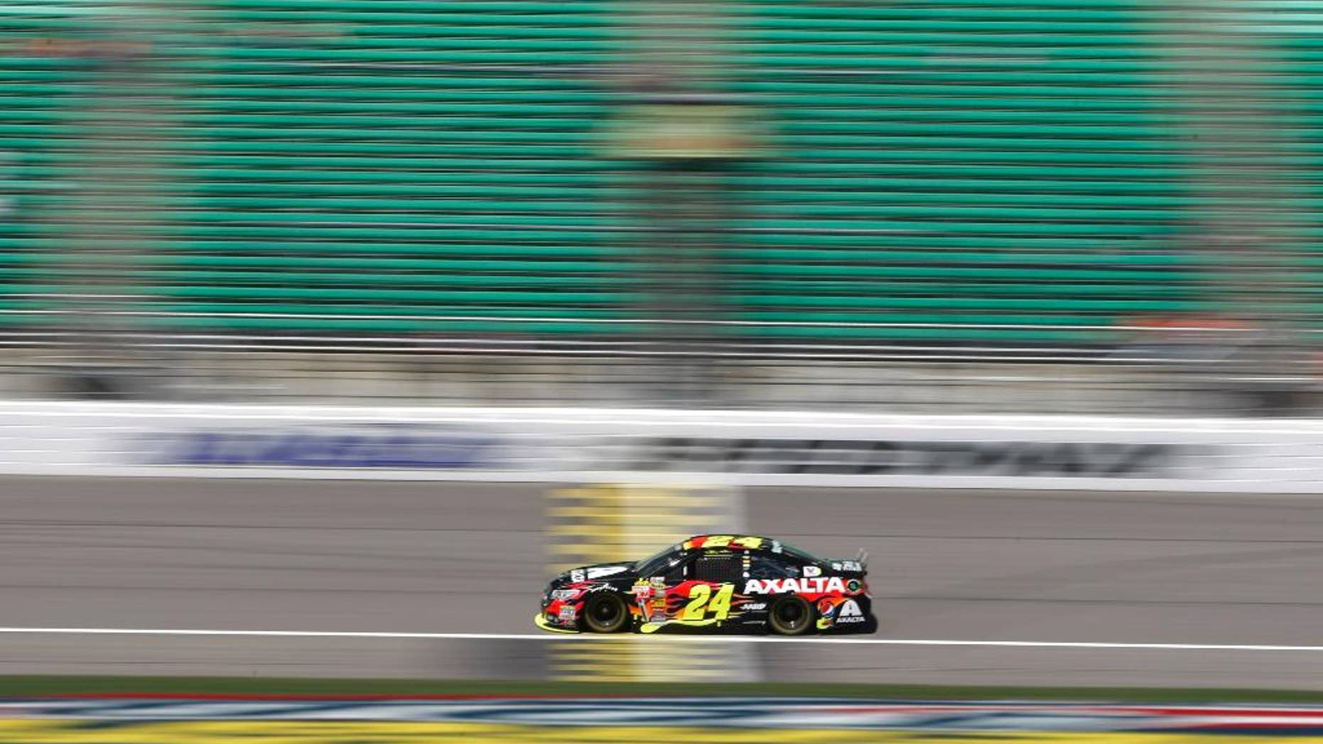 In this image taken with a slow shutter speed, driver Jeff Gordon (24) takes a practice lap Friday, May 9, 2014, at Kansas Speedway in Kansas City, Kan., for Saturday night's NASCAR Sprint Cup series auto race. (AP Photo/Colin E. Braley)