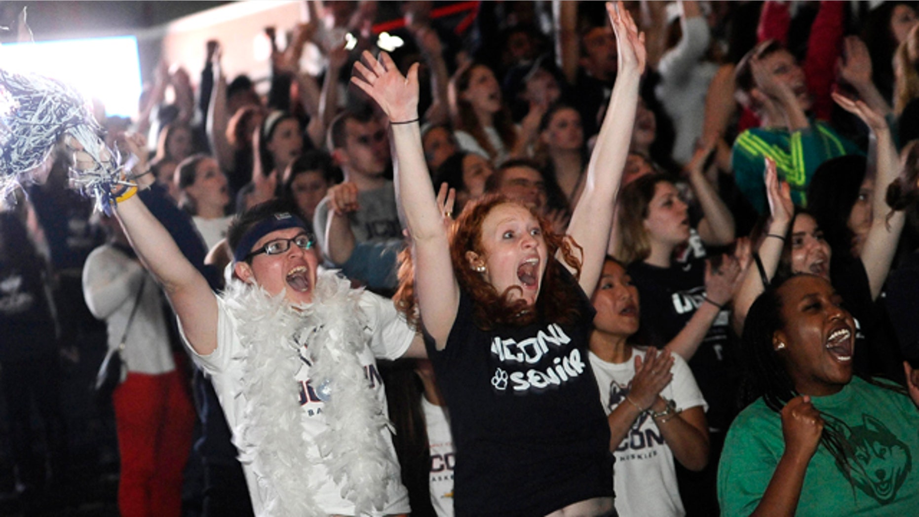 April 8, 2014: Husein Becirovic of New Britain, Conn., left, Laura Purcell of Stoughton, Mass., center, and Yvonne Ambenge of Mansfield, Conn., right, cheer as they watch the broadcast of the UConn-Notre Dame women's basketball game for the NCAA title in Storrs, Conn. (AP Photo/Jessica Hill)