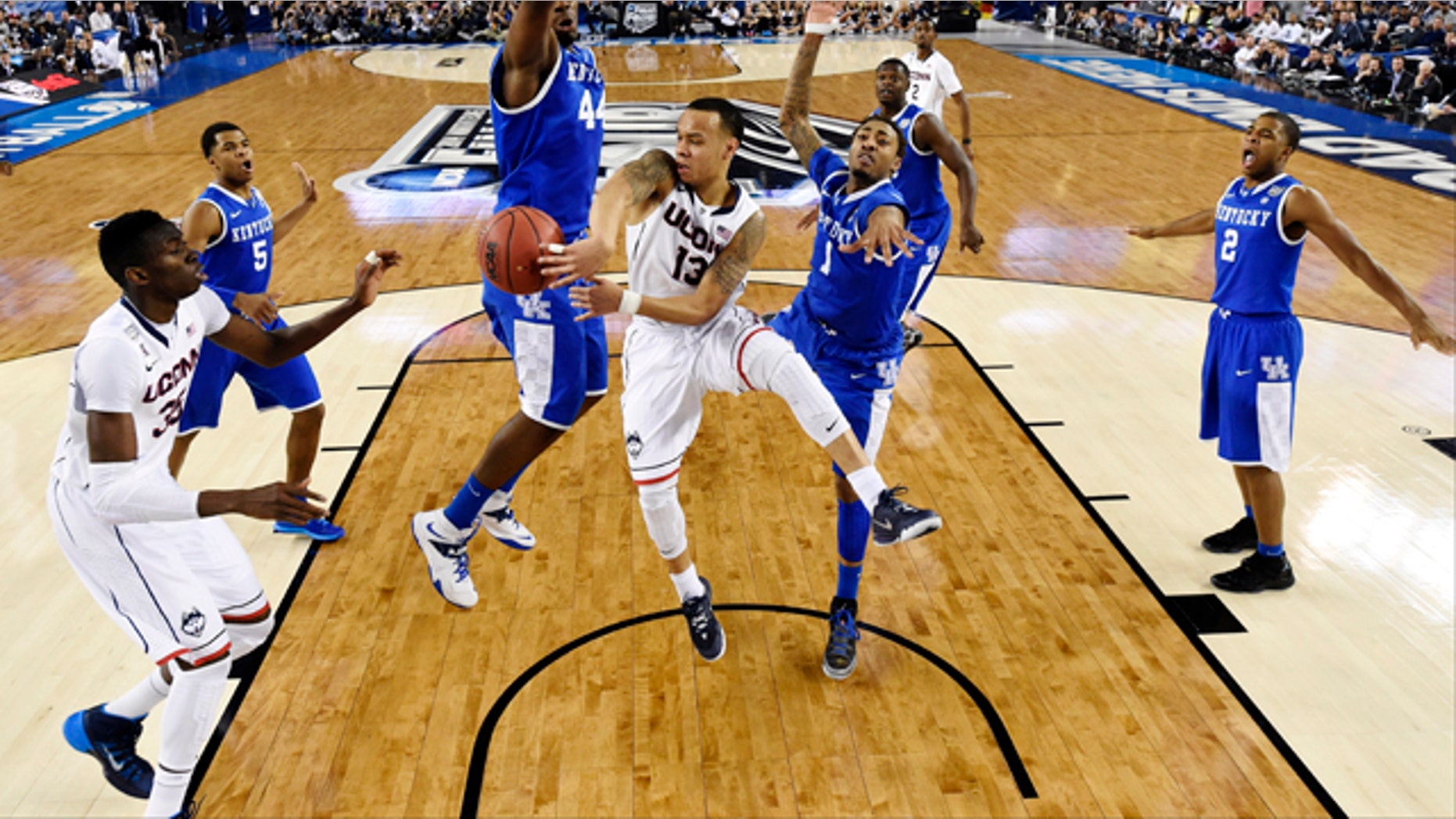 April 7, 2014: Connecticut guard Shabazz Napier (13) passes around Kentucky center Dakari Johnson (44) to center Amida Brimah (35) as guard James Young (1) helps during the first half of the NCAA Final Four tournament college basketball championship game in Arlington, Texas. (AP Photo/Chris Steppig, pool)