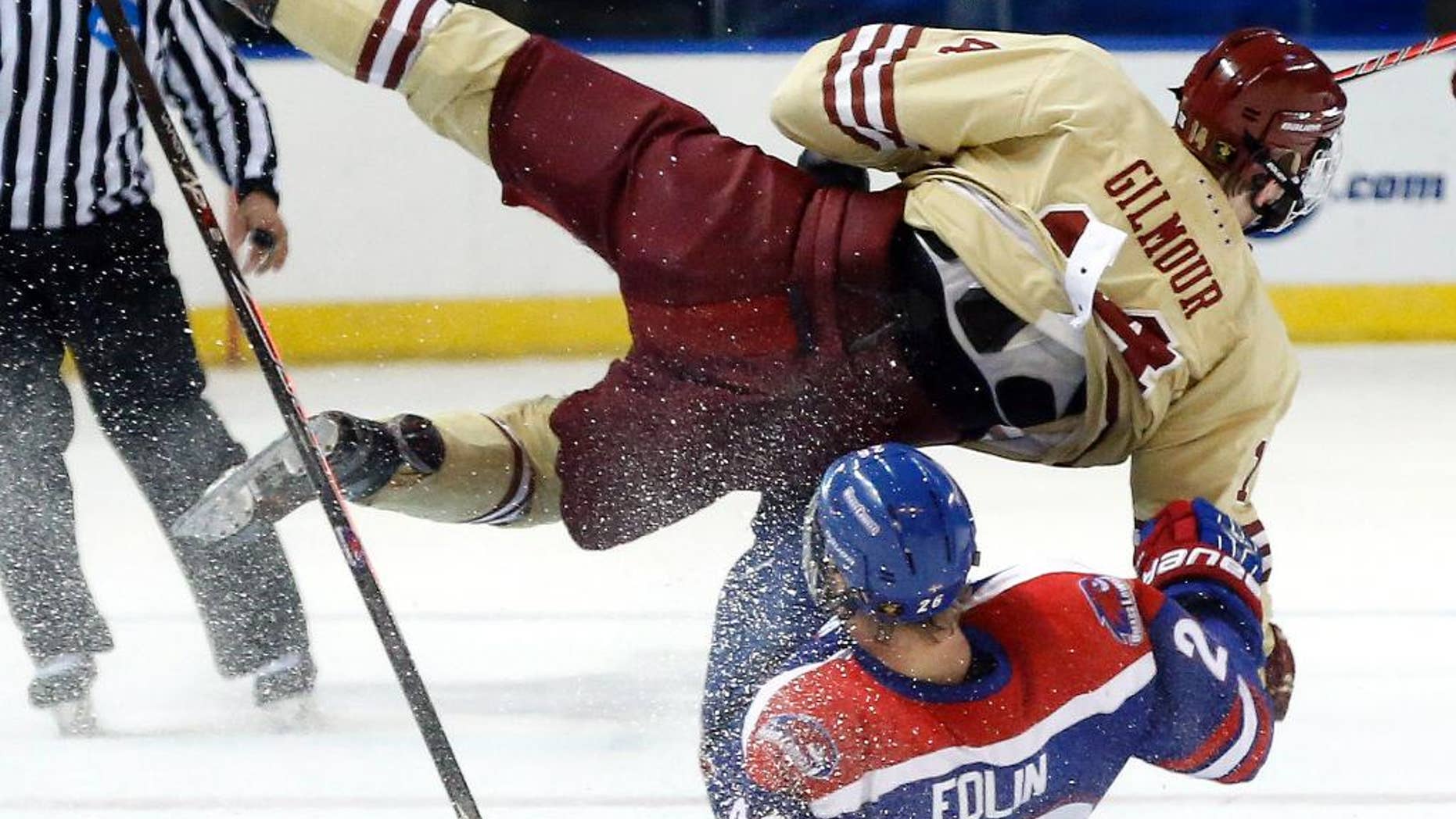 Boston College's Adam Gilmour (14) and UMass Lowell's Christian Folin (26) crash going for the puck in the first period of the NCAA Northeast Regional hockey final in Worcester, Mass., Sunday, March 30, 2014. (AP Photo/Elise Amendola)