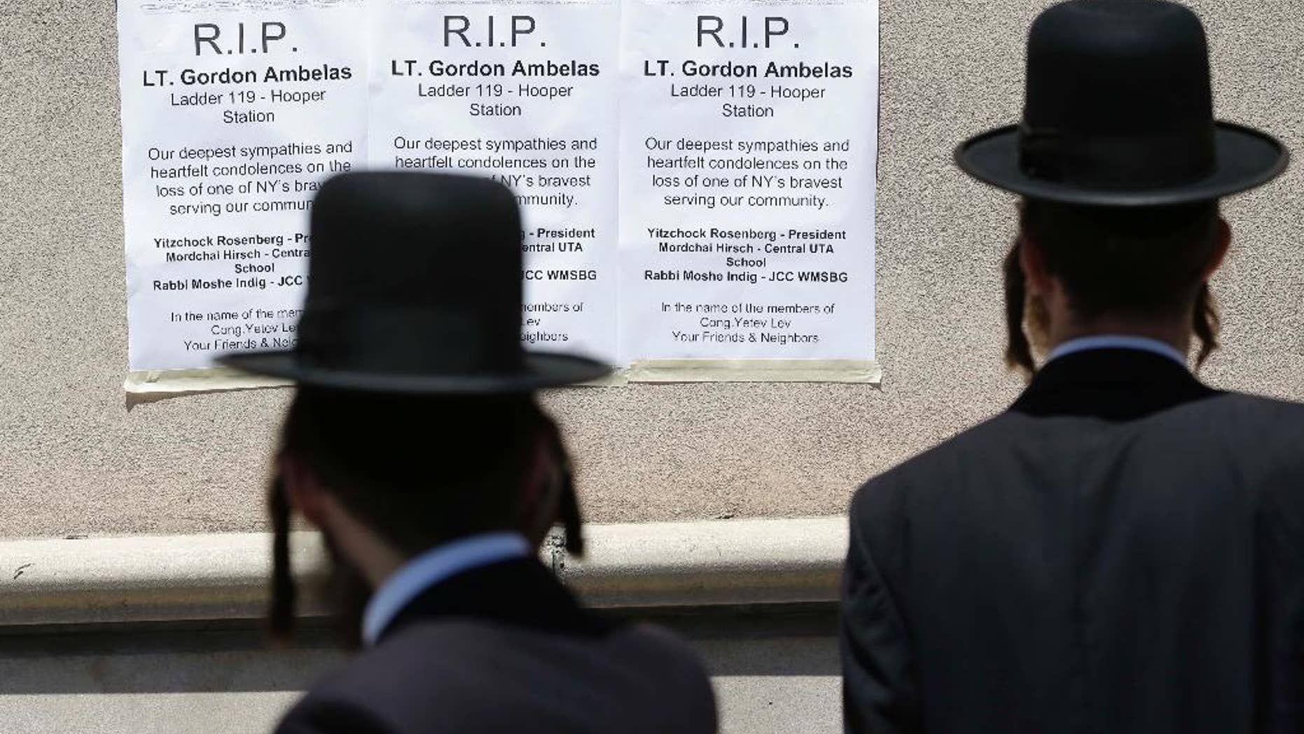 Signs commemorating Lt. Gordon Ambelas are displayed across the street from a firehouse in New York, Sunday, July 6, 2014. The Fire Department of New York is mourning the death of Ambelas, who became trapped while looking for victims in a public-housing high-rise blaze, the first to die in the line of duty in more than two years. Ambelas died Saturday after suffering multiple injuries while on the 19th floor of the 21-story building in the Williamsburg section of Brooklyn, officials said. (AP Photo/Seth Wenig)