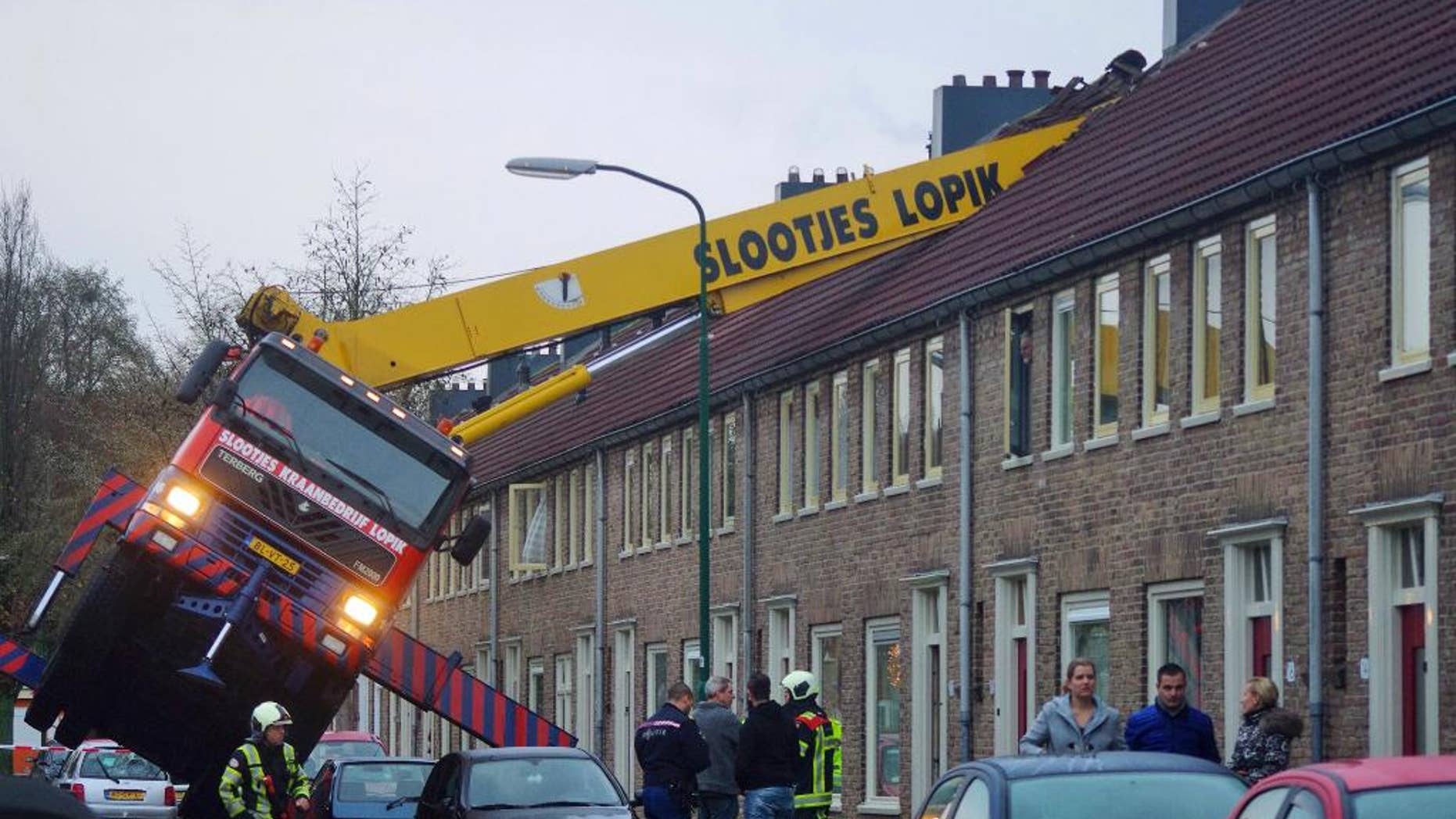 A crane which crashed into the roof of a house is seen following an unusual marriage proposal by a man who wished to be lifted in front of the bedroom window of his girlfriend to ask for her hand in marriage, in the central Dutch town of IJsselstein, Saturday Dec. 13, 2014. No people were injured in the accident, the groom-to-be jumped to safety without injuries and his girlfriend accepted to marry him, according to local Dutch media. (AP Photo/AS Media) NETHERLANDS OUT, MANDATORY CREDIT
