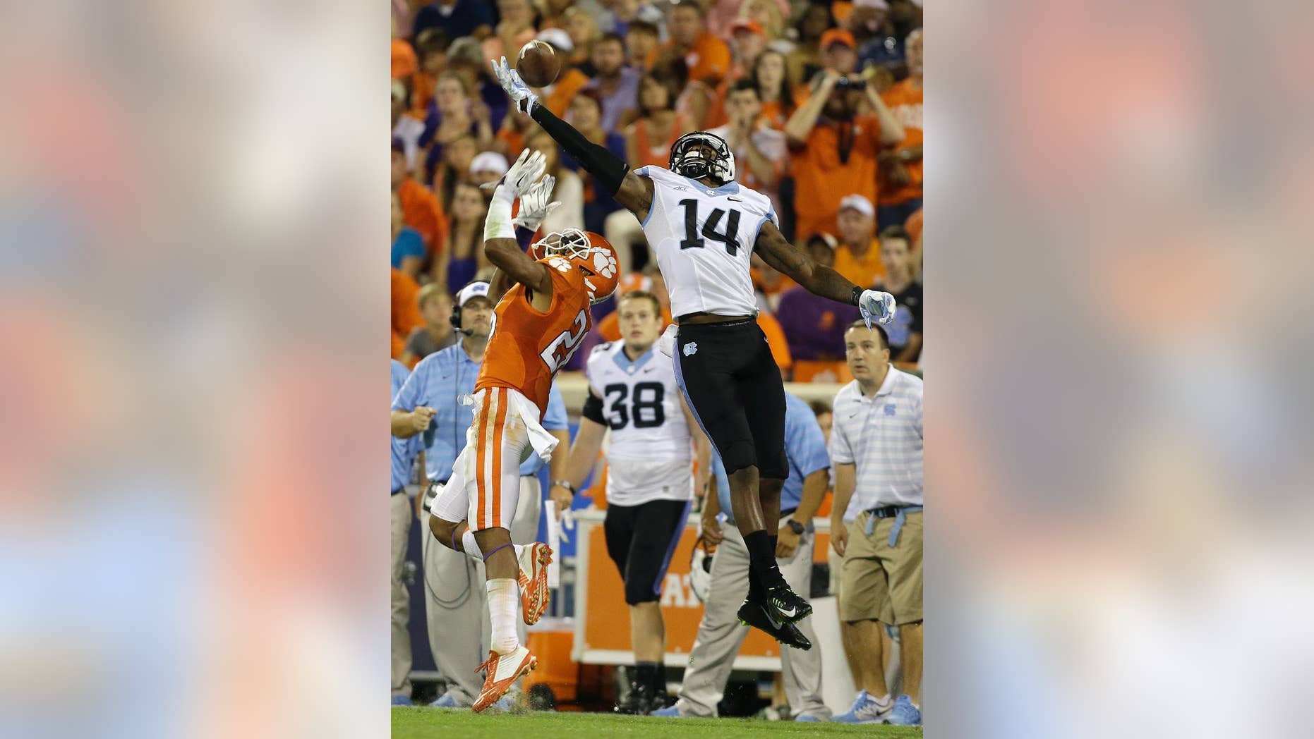 North Carolina's Quinshad Davis (14) stretches to make the catch as Clemson's Garry Peters (26) tries to break up the play during the second half of an NCAA college football game in Clemson, S.C., Saturday Sept. 27, 2014. Clemson won 50-35. (AP Photo/Bob Leverone)