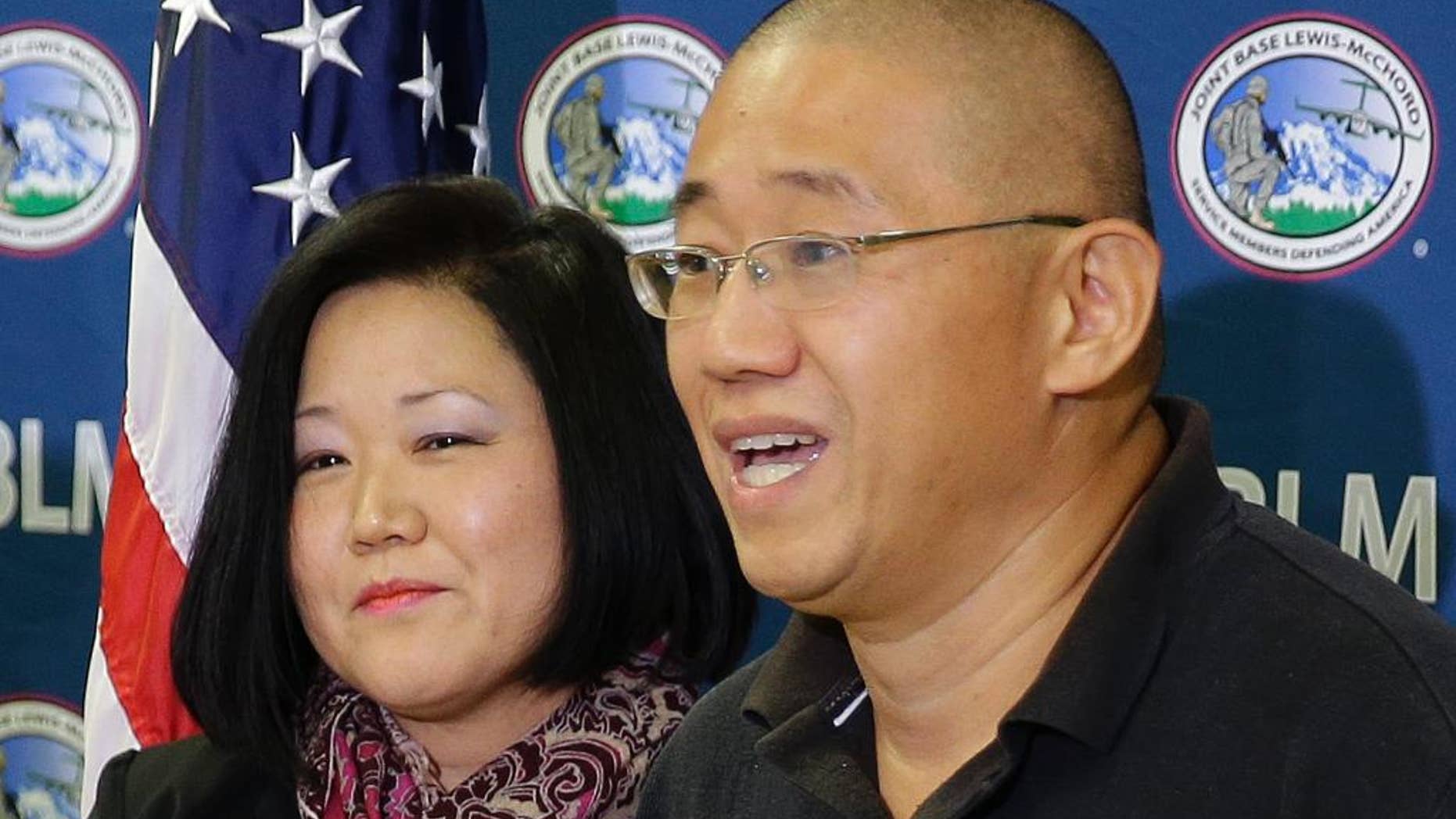 Kenneth Bae, right, who had been held in North Korea since 2012, talks to reporters after he arrived Saturday, Nov. 8, 2014, at Joint Base Lewis-McChord, Wash., after he was freed during a top-secret mission. At left is his sister Terri Chung. (AP Photo/Ted S. Warren)