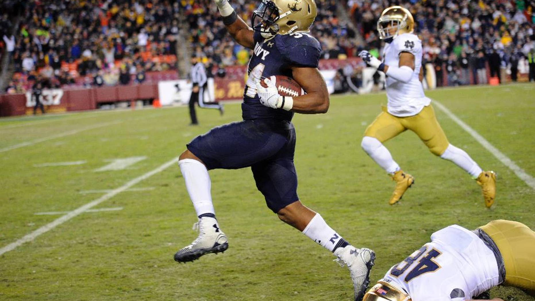 Navy fullback Noah Copeland, left, runs away from Notre Dame linebacker Greer Martini (48) during the second half of an NCAA college football game, Saturday, Nov. 1, 2014, in Landover, Md. Notre Dame won 49-39. (AP Photo/Nick Wass)