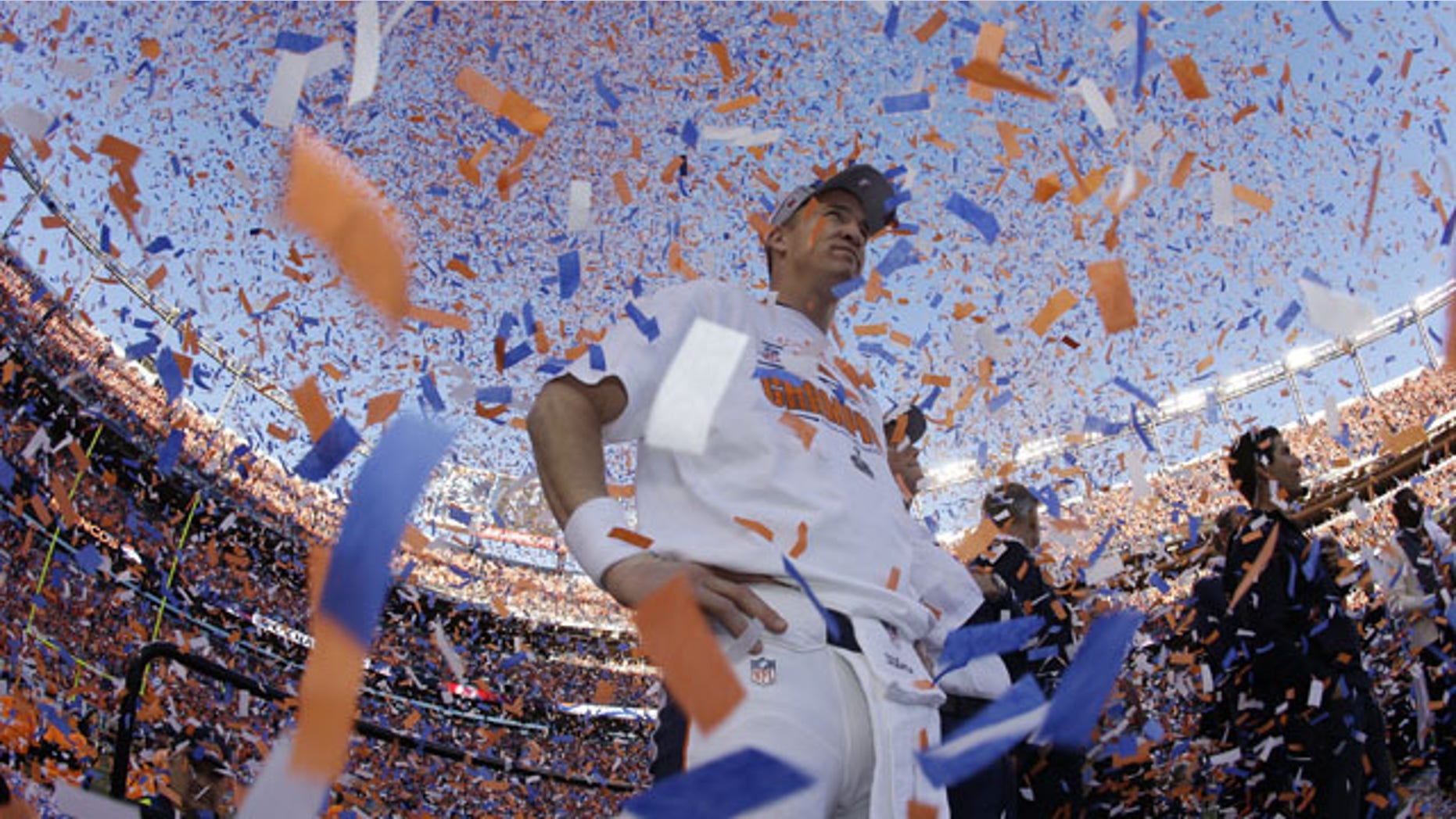 January 19, 2014: Denver Broncos quarterback Peyton Manning is engulfed in confetti during the trophy ceremony after the AFC Championship NFL playoff football game in Denver. The Broncos defeated the Patriots 26-16 to advance to the Super Bowl. (AP Photo/Charlie Riedel)