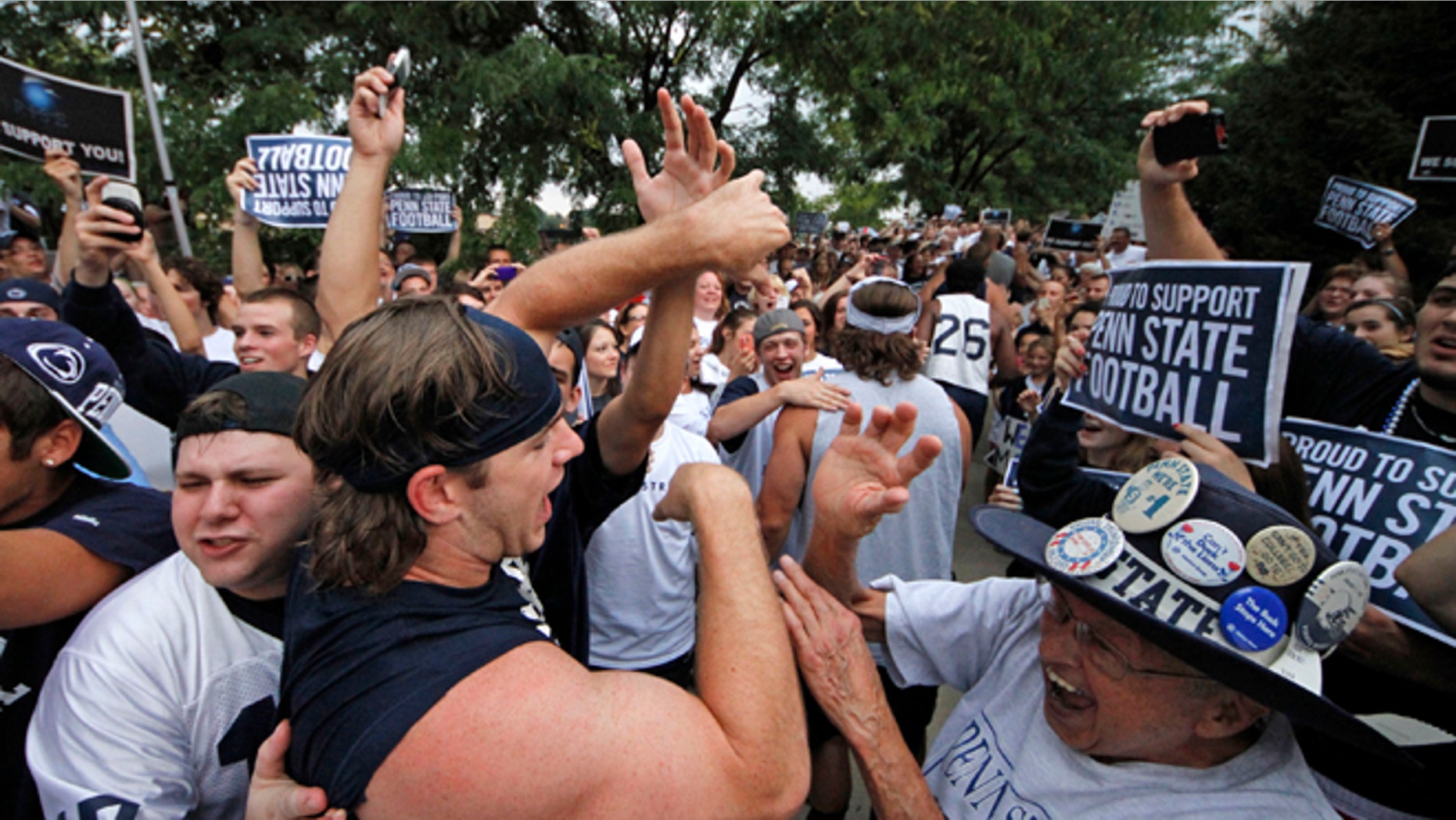 July 31, 2012: Penn State University linebacker Michael Mauti, second from left foreground, and his teammates are greeted by a pep rally of supporters on the way to a morning workout outside the Lasch Football building on the Penn State main campus in State College, Pa.