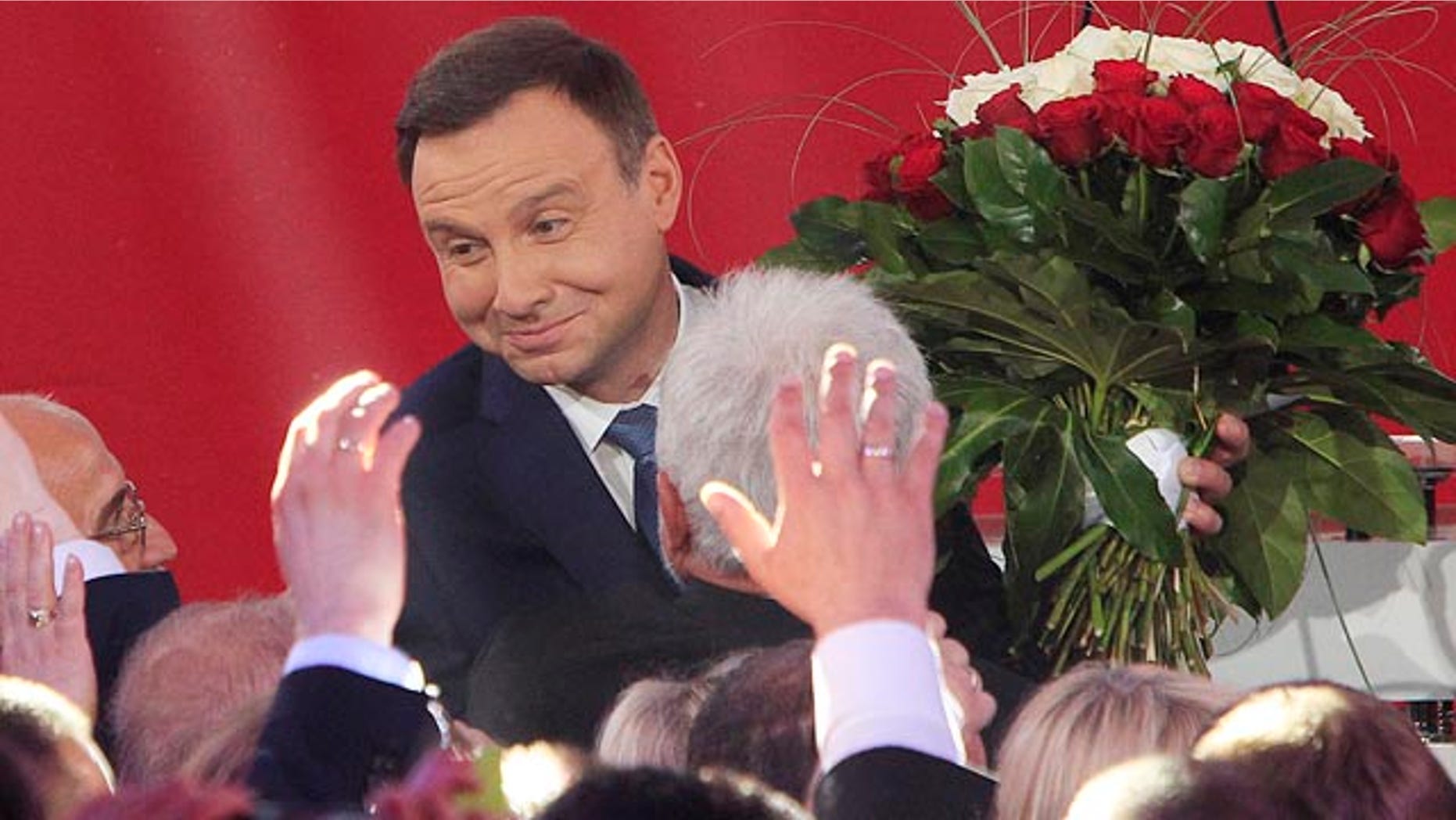 May 24, 2015: Opposition candidate Andrzej Duda celebrates with supporters as the first exit polls in the presidential runoff voting are announced in Warsaw. (AP Photo/Czarek Sokolowski)