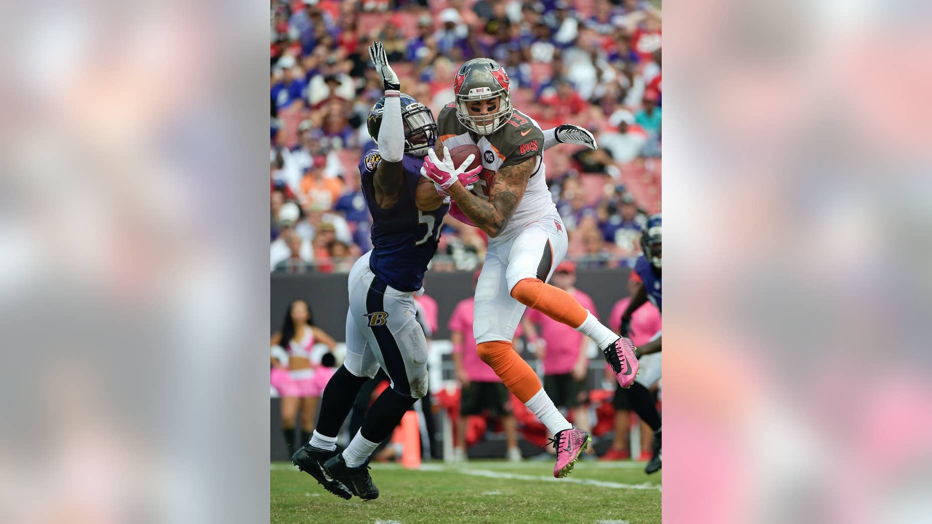 Tampa Bay Buccaneers wide receiver Mike Evans (13) catches a 17-yard touchdown pass in front of Baltimore Ravens inside linebacker C.J. Mosley, left, during the second half of an NFL football game in Tampa, Fla., Sunday, Oct. 12, 2014. (AP Photo/Phelan M. Ebenhack)
