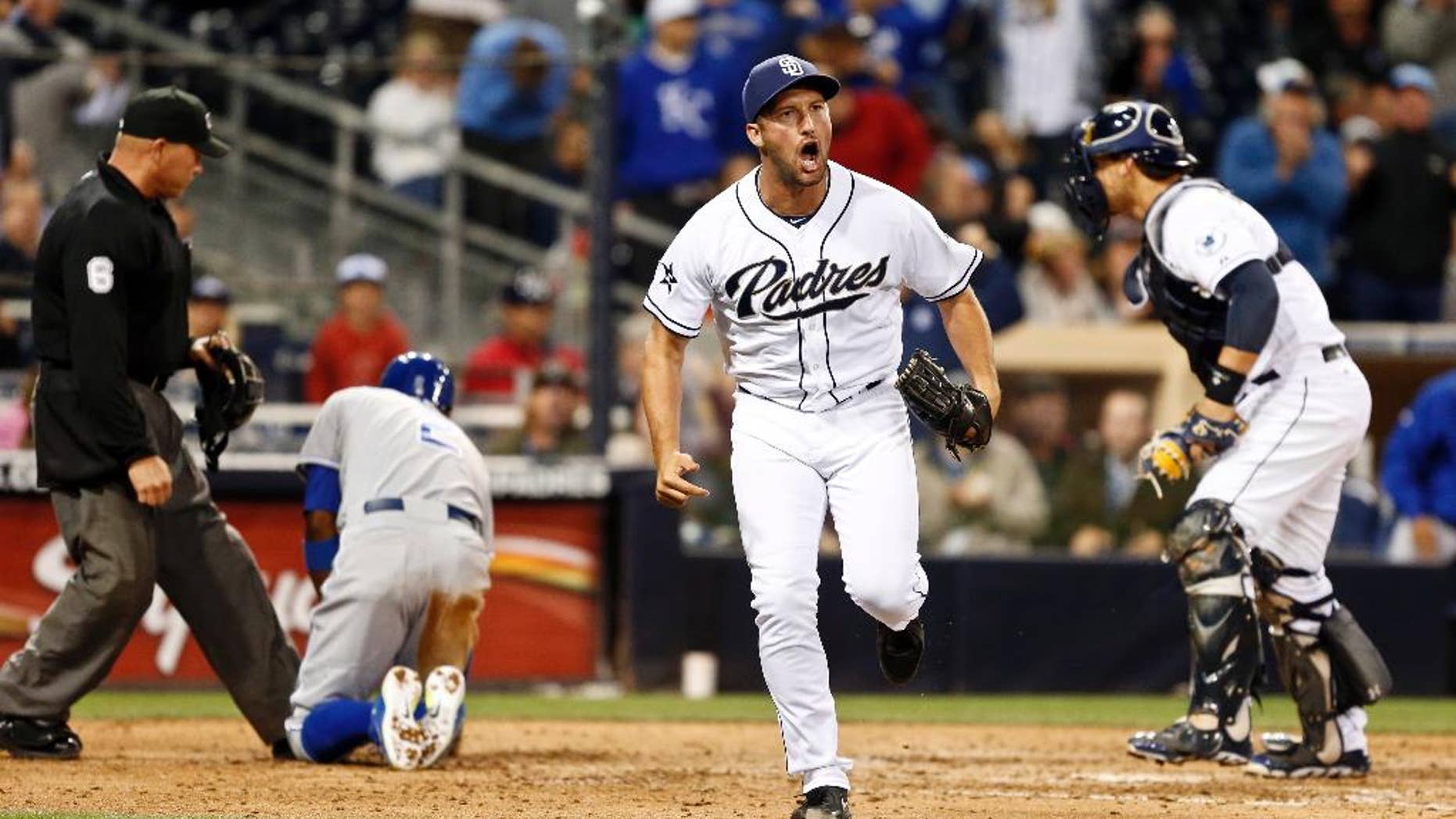 San Diego Padres relief pitcher Huston Street celebrates after Padres catcher Yasmani Grandal, right, tagged out Kansas City Royals' Alcides Escobar who was out trying to score from third on a pop out down the right field line during the ninth inning of a tied baseball game Tuesday, May 6, 2014, in San Diego. (AP Photo/Lenny Ignelzi)