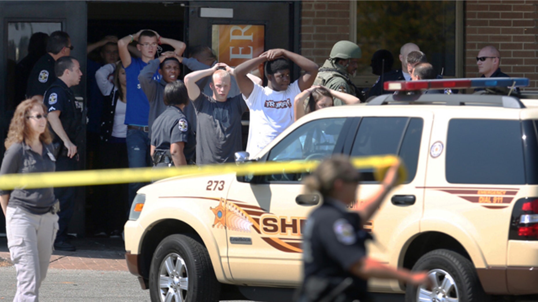 September 30, 2014: Students put their hands on their heads as they are led out of Fern Creek High School in Louisville, Ky. (AP Photo/The Courier-Journal, Scott Utterback)