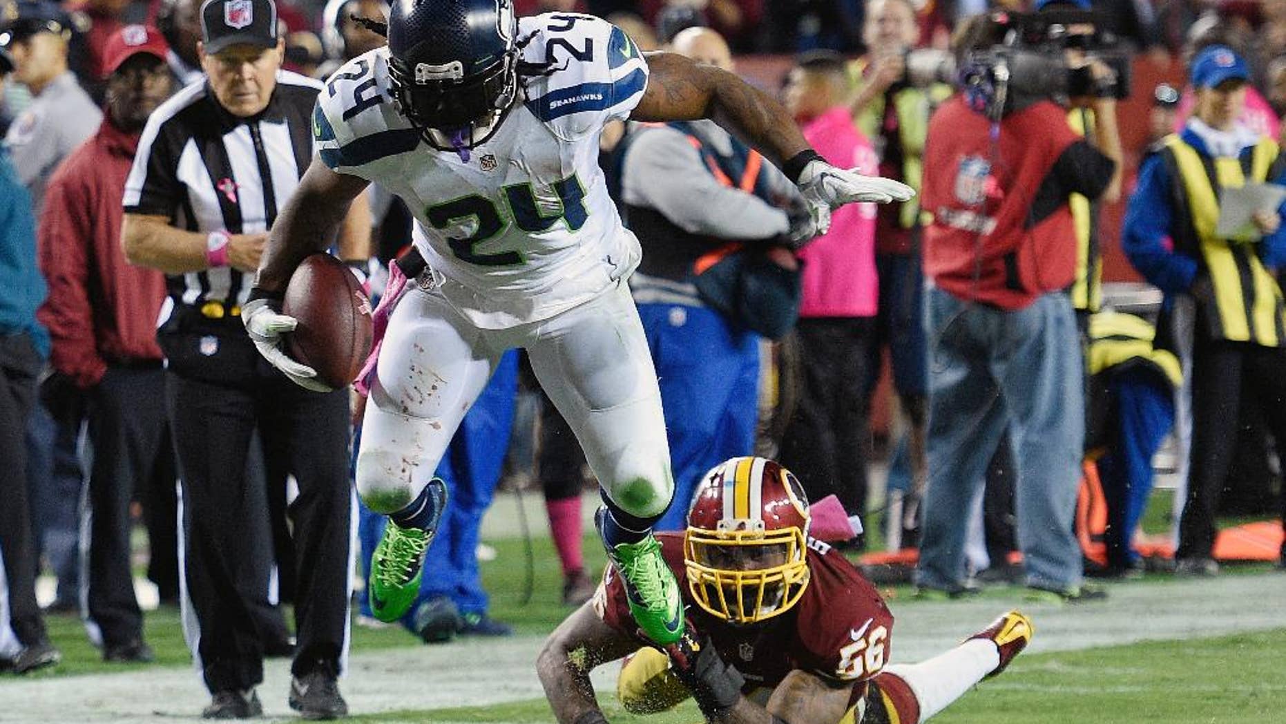 Seattle Seahawks running back Marshawn Lynch (24) breaks a tackle by Washington Redskins inside linebacker Perry Riley (56) on his way to a touchdown during the second half of an NFL football game in Landover, Md., Monday, Oct. 6, 2014. (AP Photo/Nick Wass)