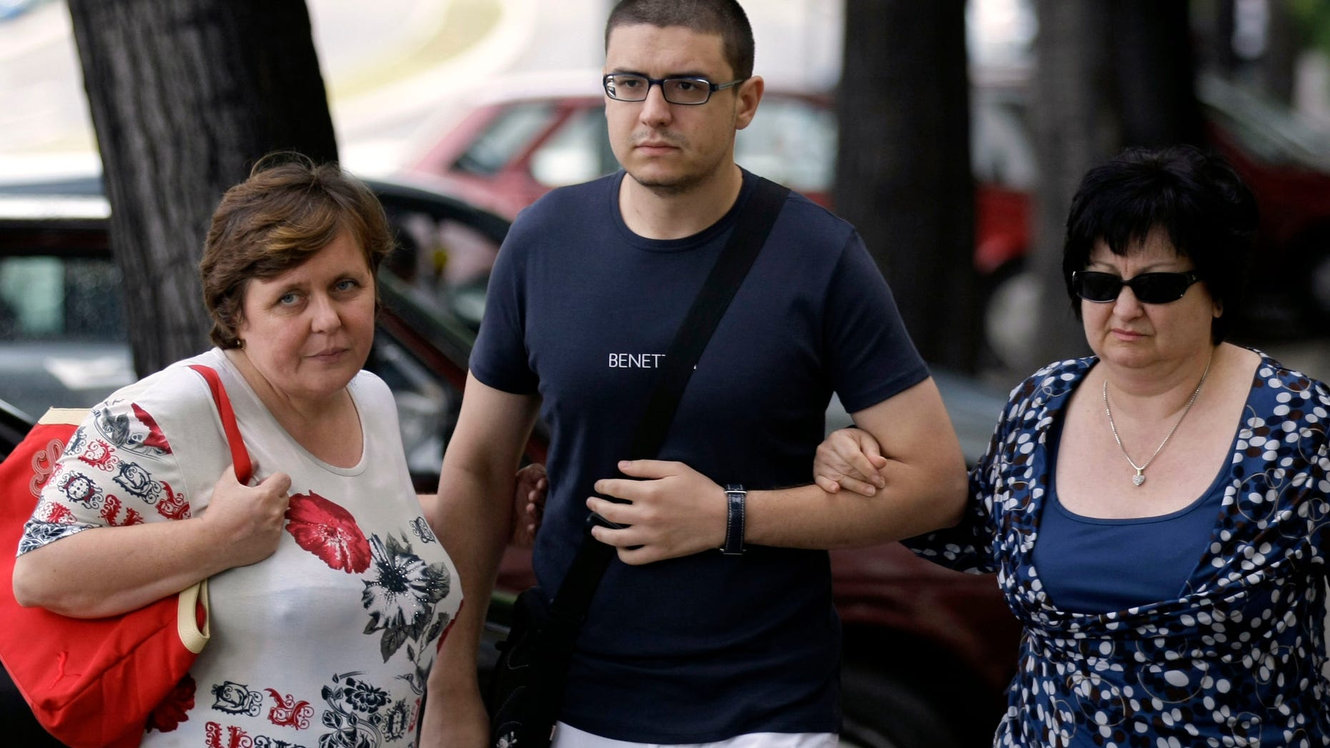 Goran Hadzic's son Srecko Hadzic, center, wife Zivka Hadzic, right and sister Goranka Meseldzija, arrive at the Special Court building in Belgrade, Serbia, Thursday, July 21, 2011.