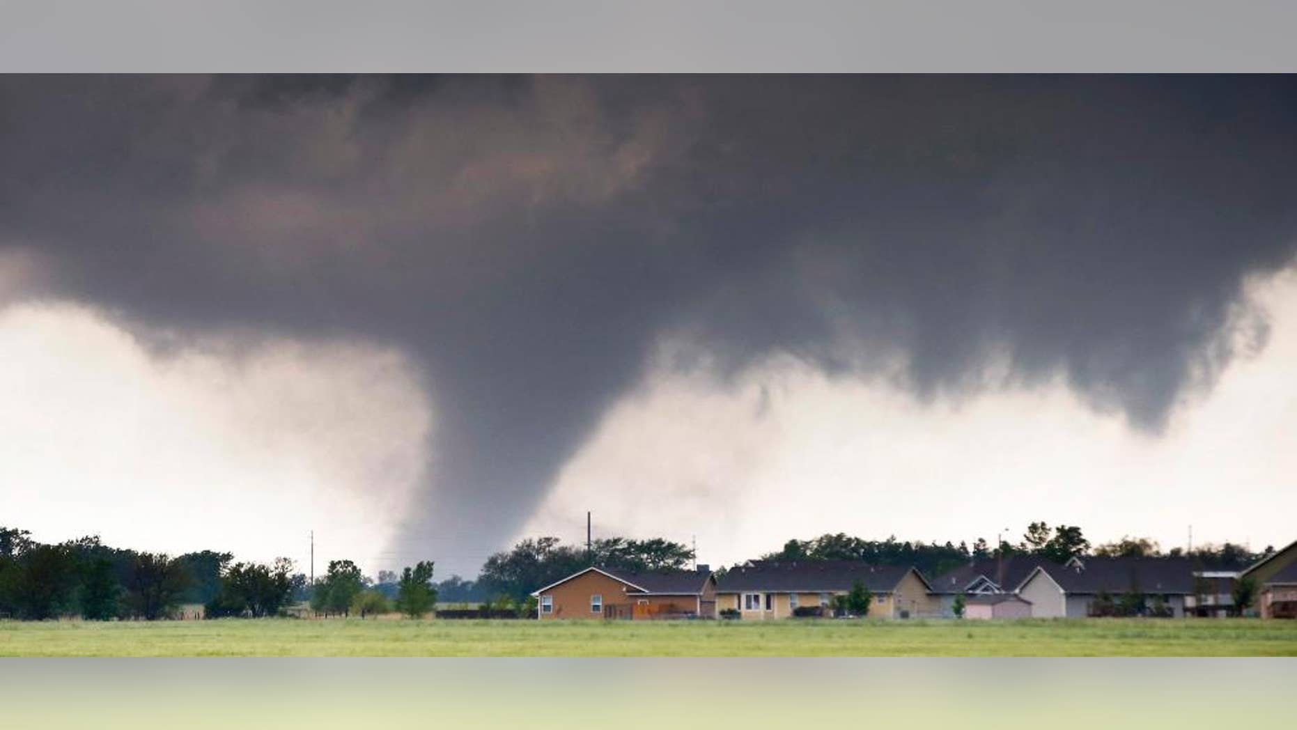 A tornado passes near Halstead, Kan., Wednesday, May 6, 2015. A swath of the Great Plains is under a tornado watch Wednesday, including parts of North Texas, Oklahoma, Kansas and Nebraska. (Travis Heying/The Wichita Eagle via AP)