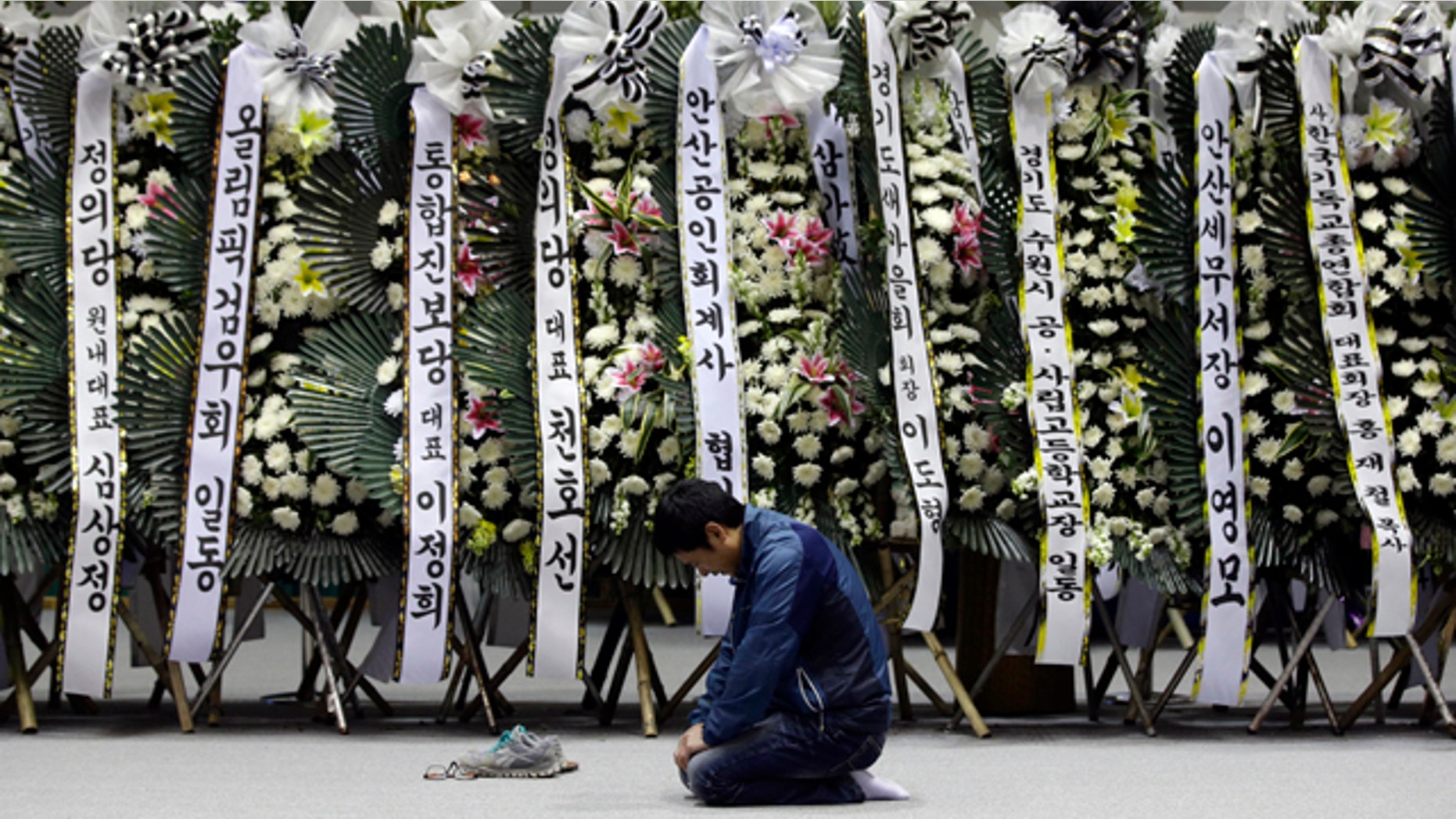 April 24, 2014: A mourner pays tribute to the victims of the sunken ferry Sewol near condolence flowers during a temporary memorial at the auditorium of the Olympic Memorial Museum in Ansan, south of Seoul, South Korea. (AP Photo/Lee Jin-man)