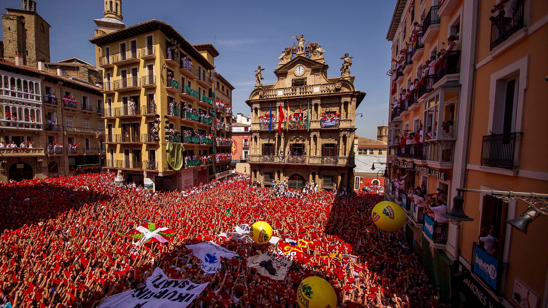Revelers hold up traditional red neckties during the launch of the "Chupinazo" rocket, to celebrate the official opening of the 2015 San Fermin fiestas in Pamplona, Spain, Monday, July 6, 2015. Revelers from around the world turned out here to kick off the festival with a messy party in the Pamplona town square, one day before the first of eight days of the running of the bulls. (AP Photo/Andres Kudacki)