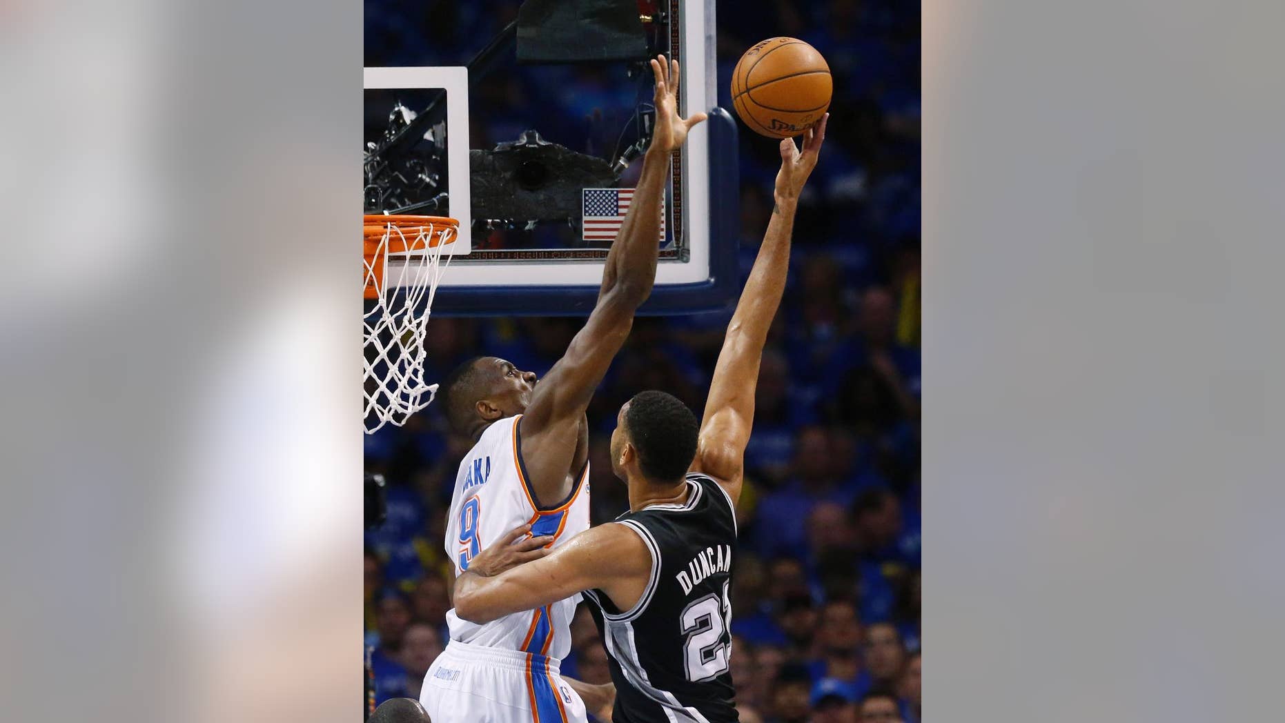 Oklahoma City Thunder forward Serge Ibaka (9) gets up to block a shot by San Antonio Spurs forward Tim Duncan (21) in the first quarter of Game 3 of an NBA basketball playoff series of the Western Conference finals, Sunday, May 25, 2014, in Oklahoma City. (AP Photo/Sue Ogrocki)