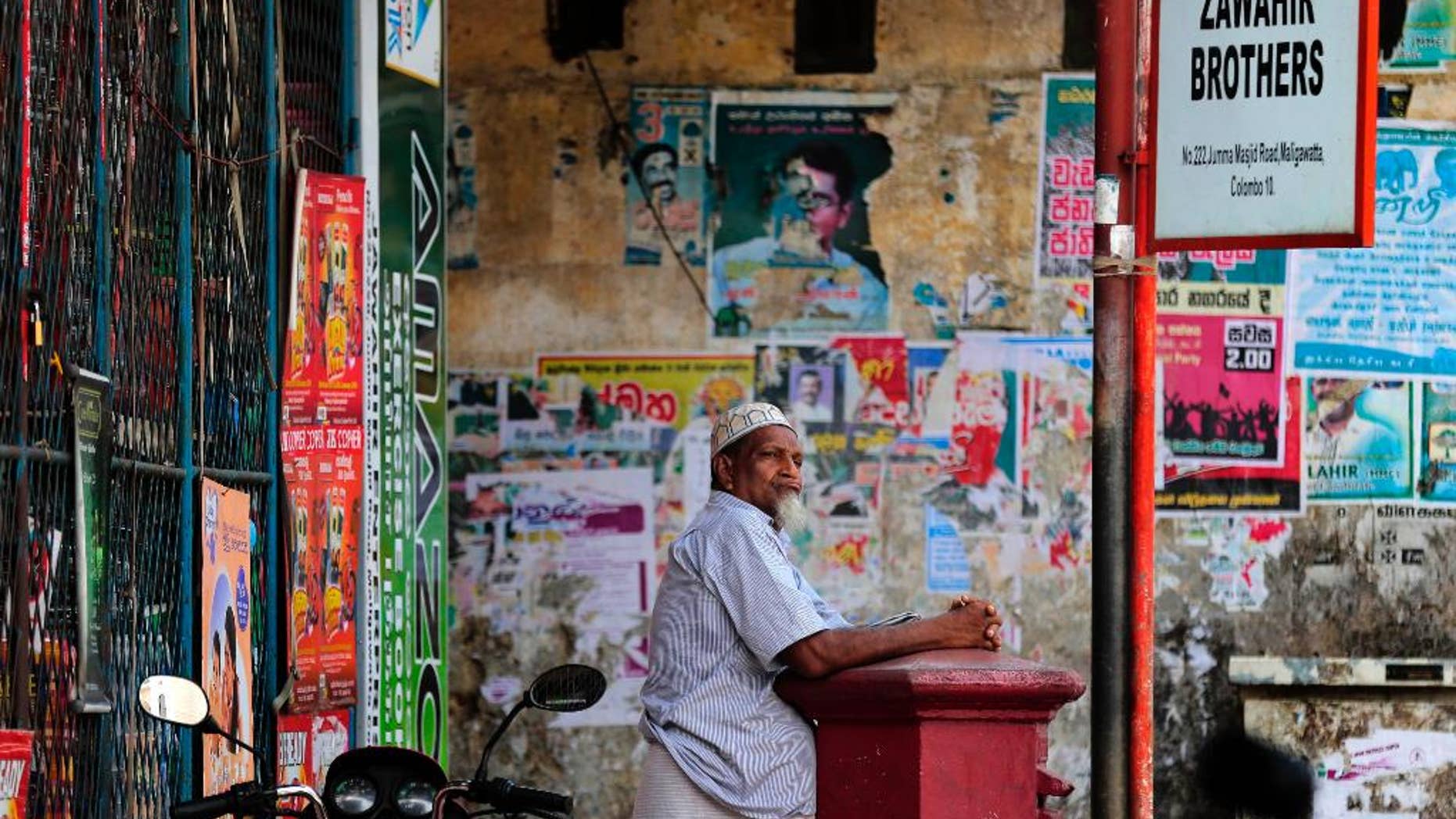 A Sri Lankan Muslim man leans against a letter box as he waits out side a closed shop during a shut down protest in Colombo, Sri Lanka, Thursday, June 19, 2014. Muslims have shut down their shops in Sri Lanka's capital to protest attacks by hard-line Buddhists on Muslims and are demanding the government punish those responsible for the violence. (AP Photo/Eranga Jayawardena)