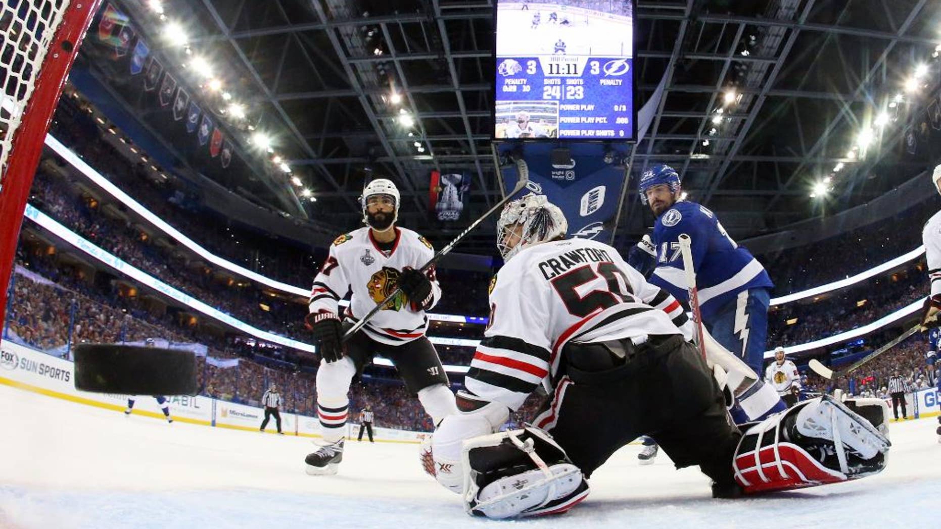 Chicago Blackhawks goalie Corey Crawford watches as Tampa Bay Lightning defenseman Jason Garrison's goal flies by during the third period in Game 2 of the NHL hockey Stanley Cup Final on Saturday, June 6, 2015, in Tampa Fla. (Bruce Bennett/Pool Photo via AP)