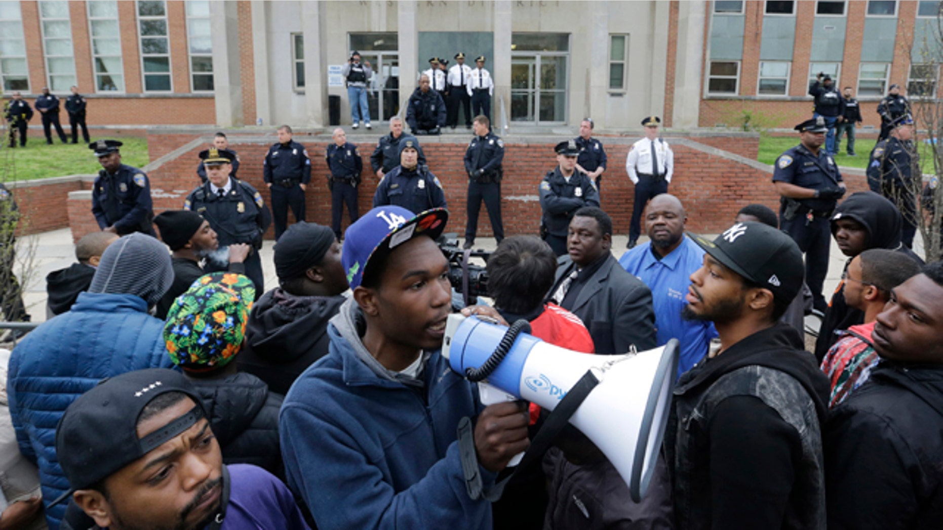 April 23, 2015: Protesters for Freddie Gray stand outside the Baltimore Police Department's Western District police station. Gray died from spinal injuries about a week after he was arrested and transported in a police van. (AP Photo/Patrick Semansky)